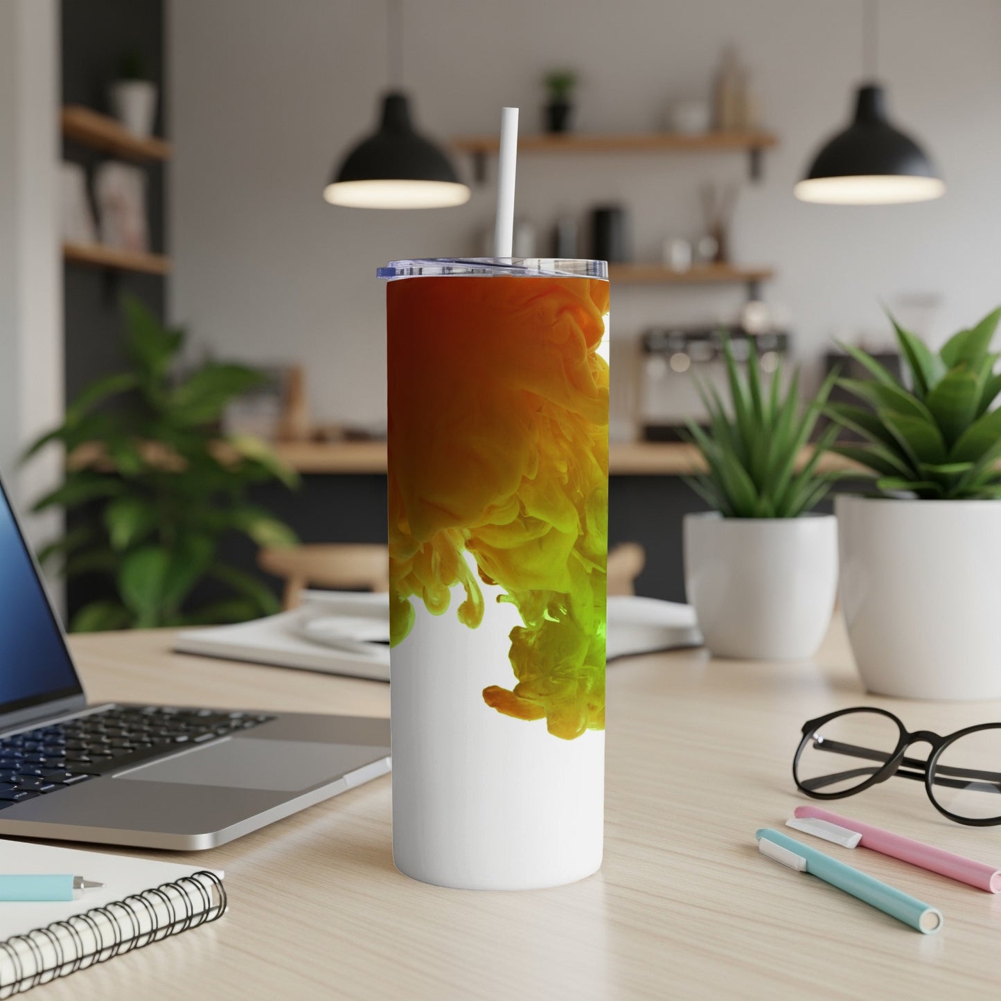 White tumbler with swirling orange and green liquid art design.