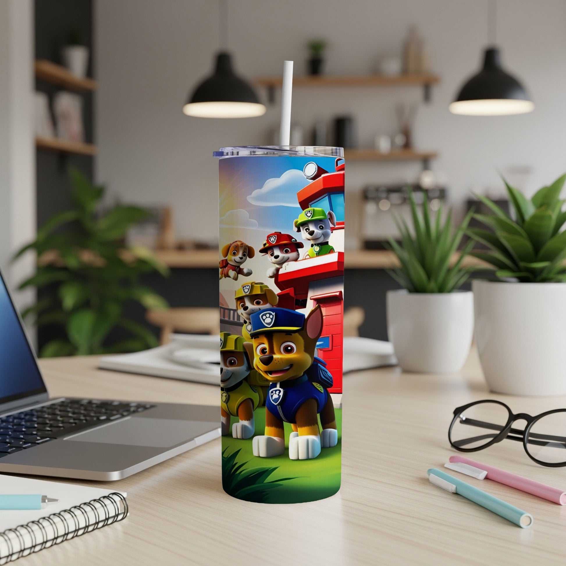 Paw Patrol characters on a tumbler with a straw, in a modern workspace.