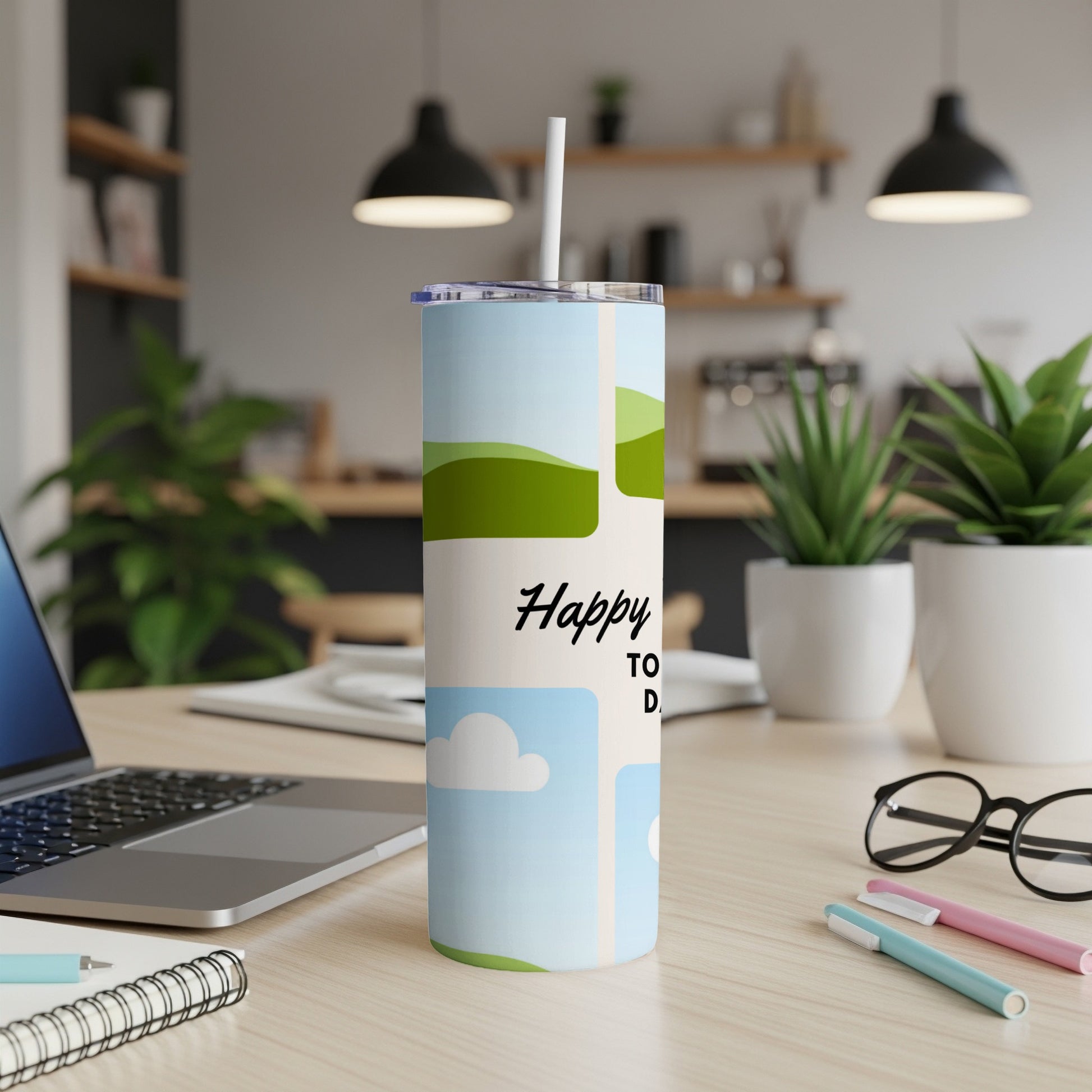 Tumbler with "Happy TO D" text and sky and landscape graphics.