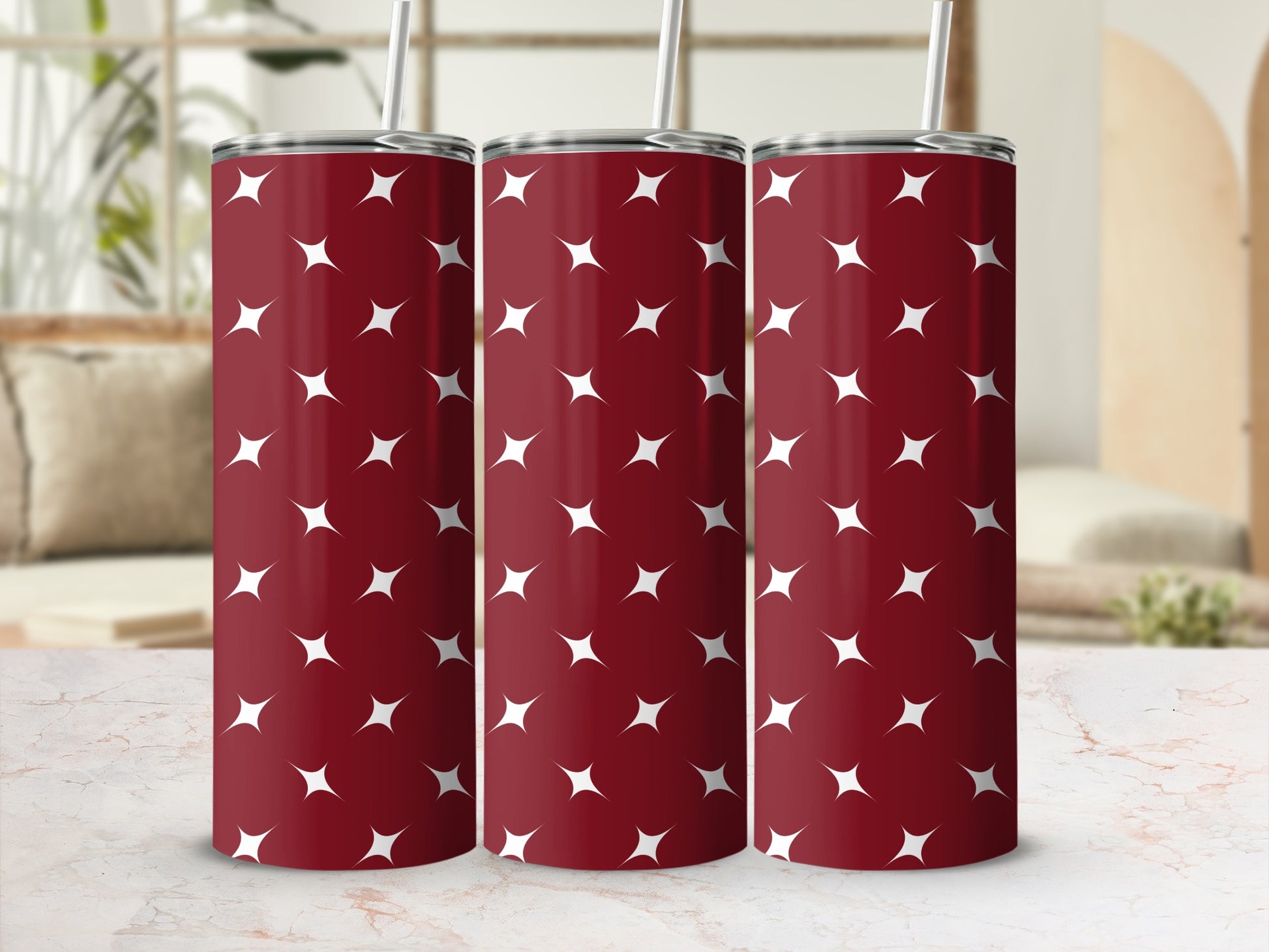 Three dark red tumblers with white star pattern and straws.