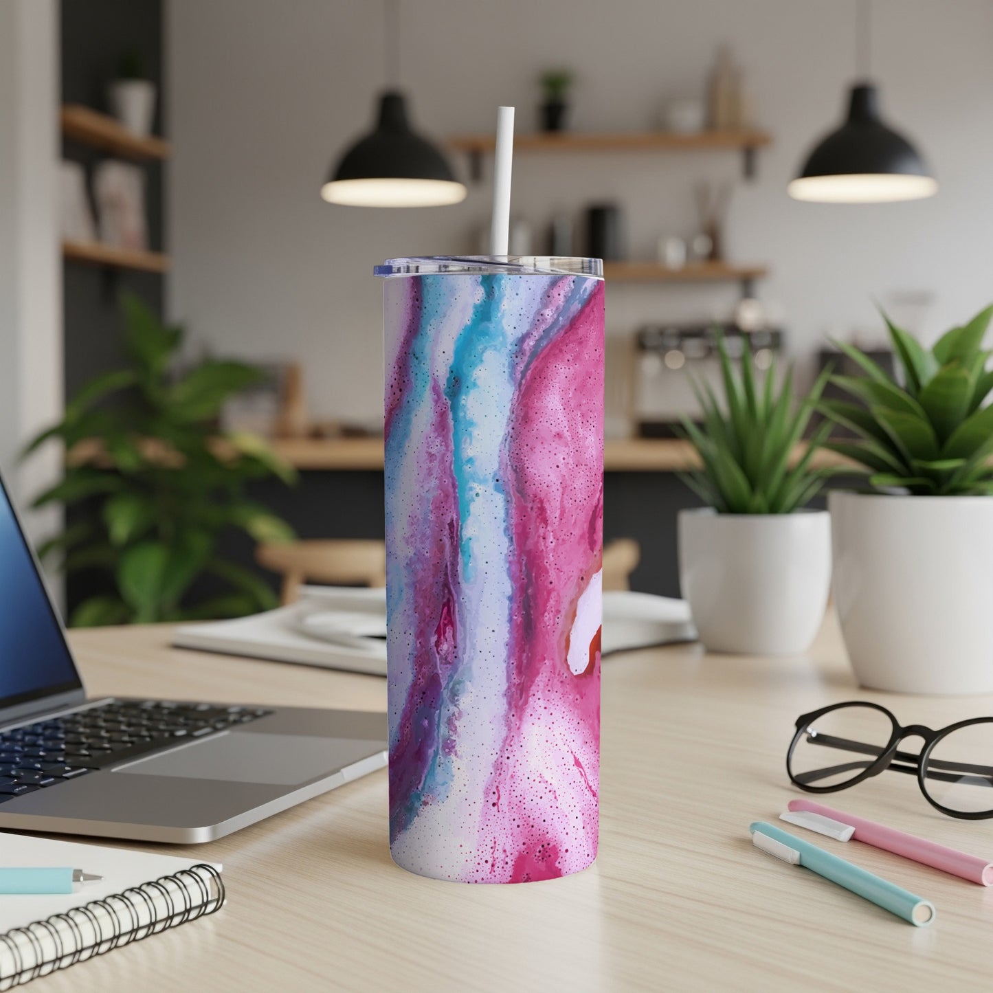 Tall tumbler with pink and blue abstract swirl pattern and straw.
