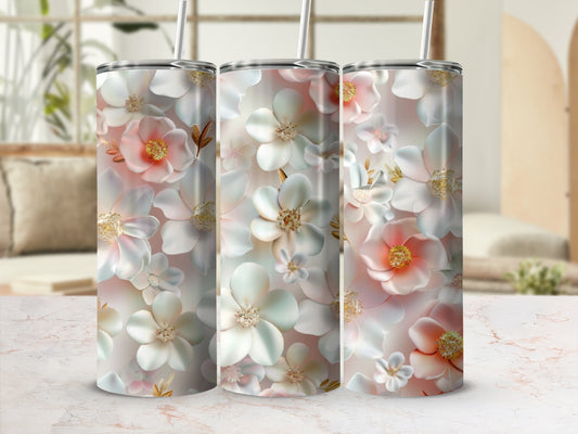 Three tumblers with delicate white and pink floral designs and straws.