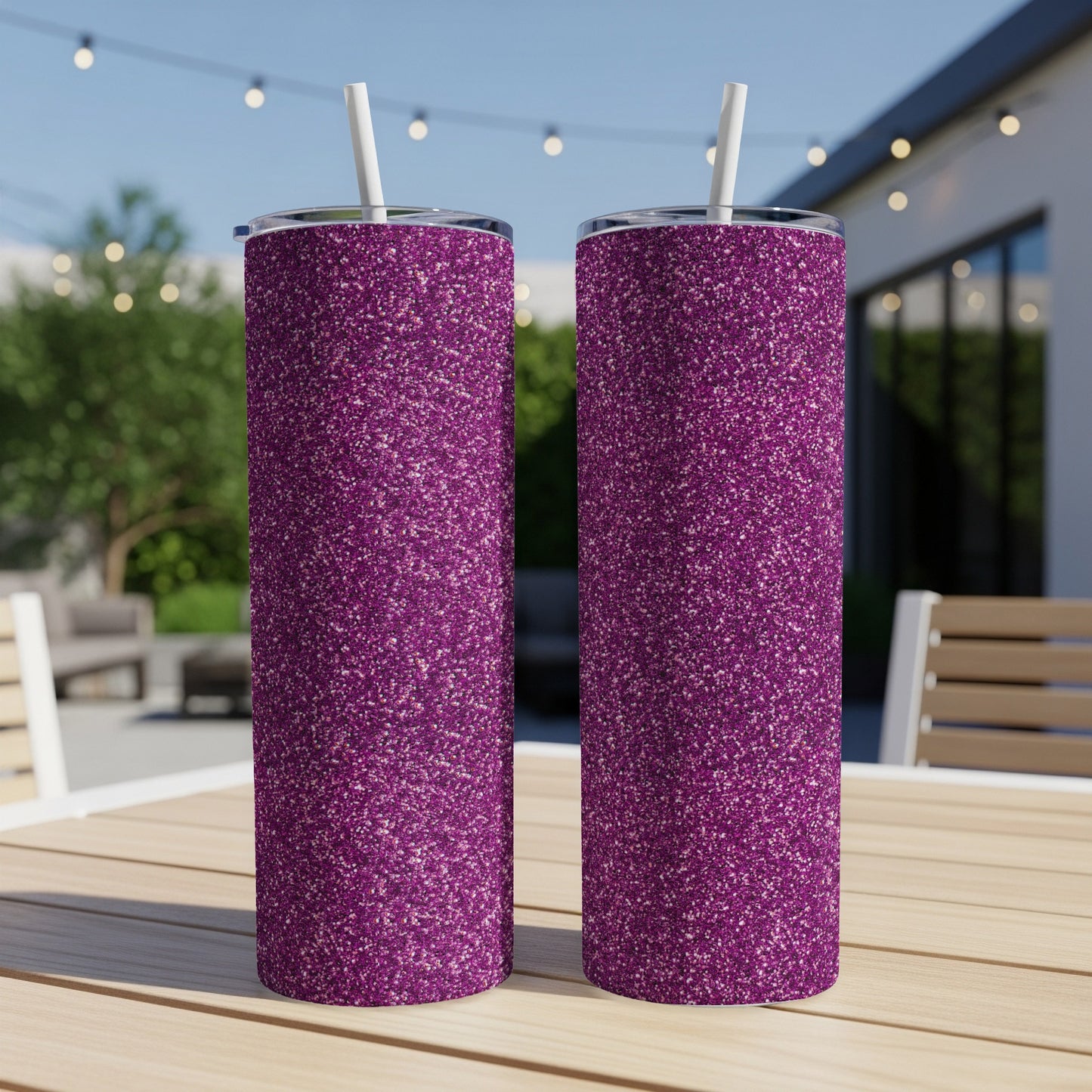 Two purple glitter tumblers with white straws sit on a wooden table.