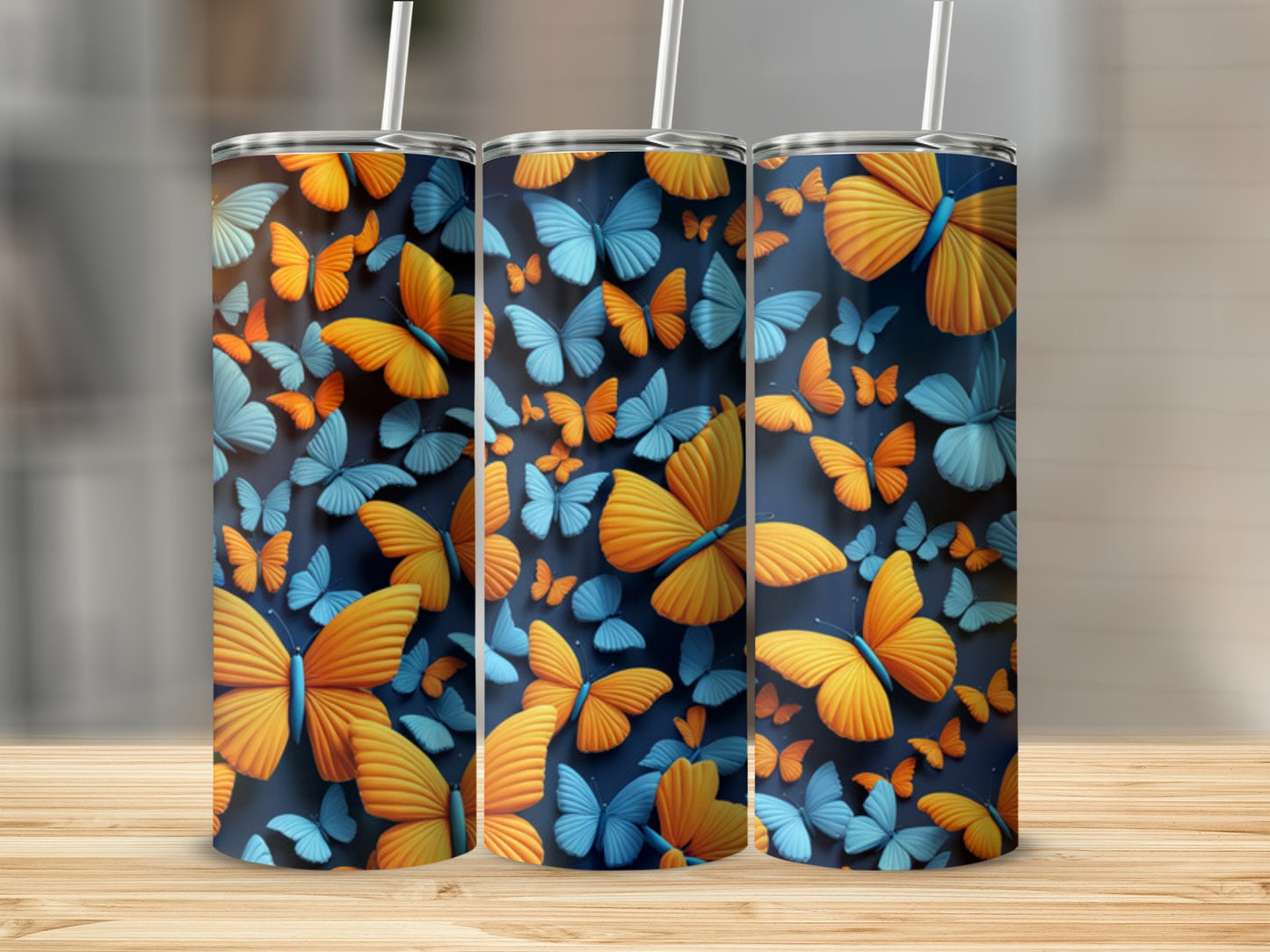 Three tumblers with a navy background and an all-over pattern of orange and blue butterflies.