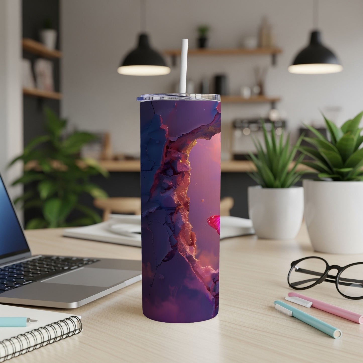 Purple abstract patterned tumbler with a straw on a desk.