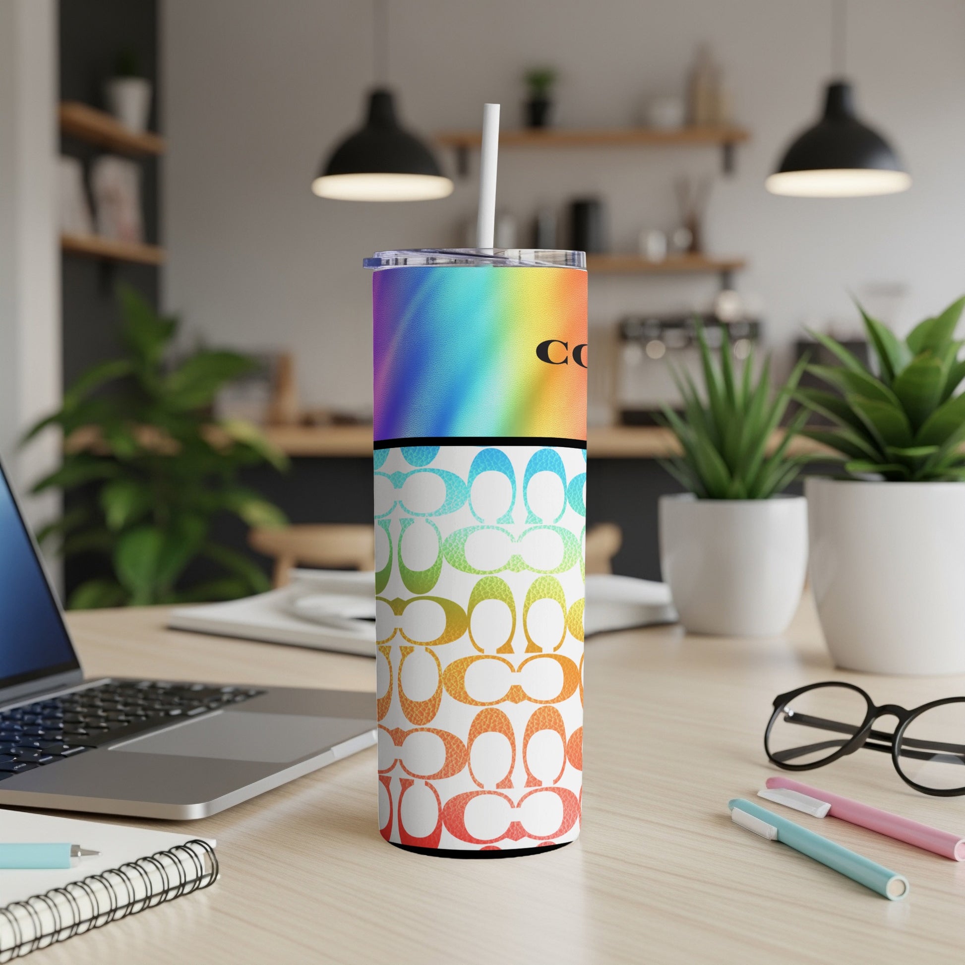 Tumbler with rainbow gradient, Coach logo, and C-pattern in ombre colors.