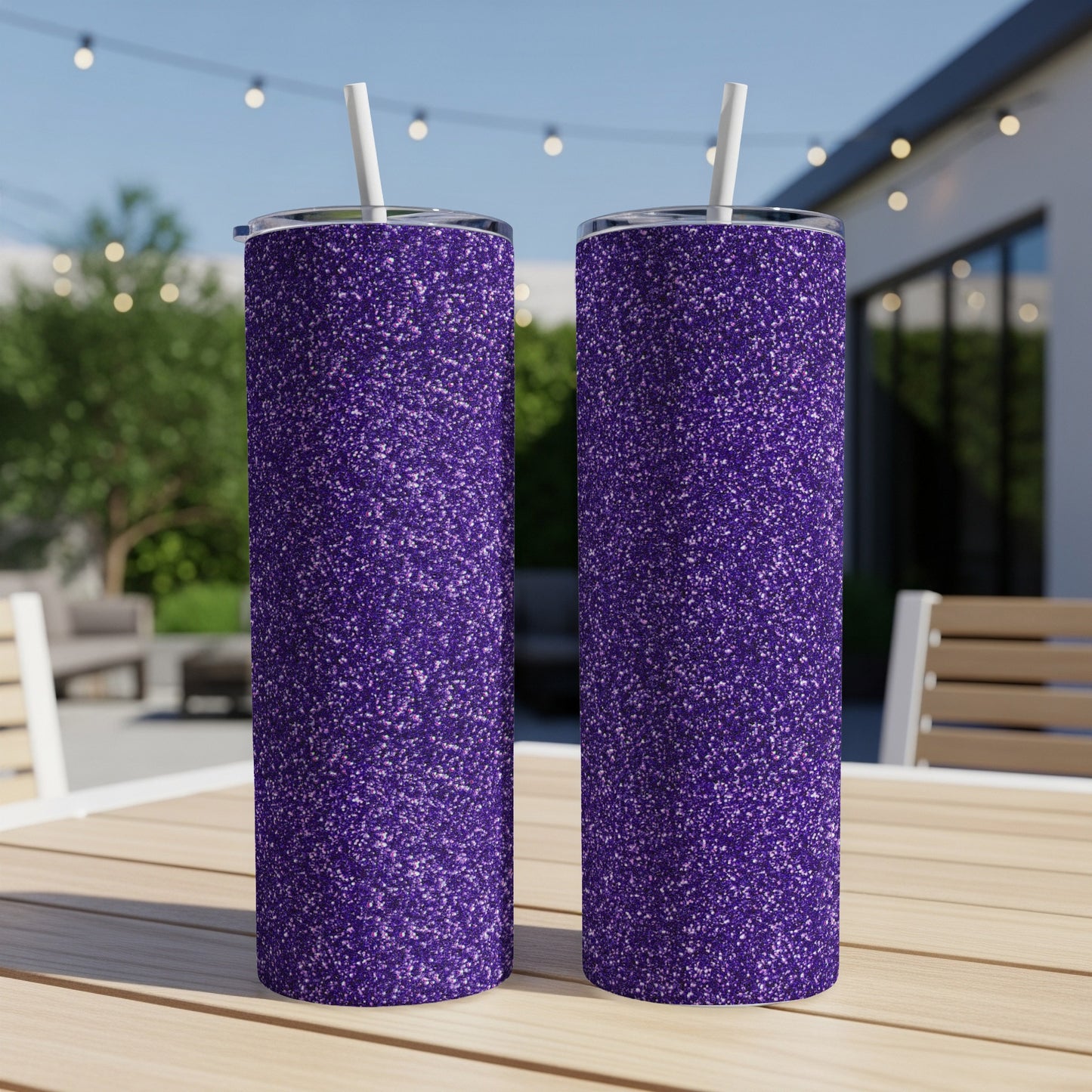 Two purple glitter tumblers with white straws on a wooden table.