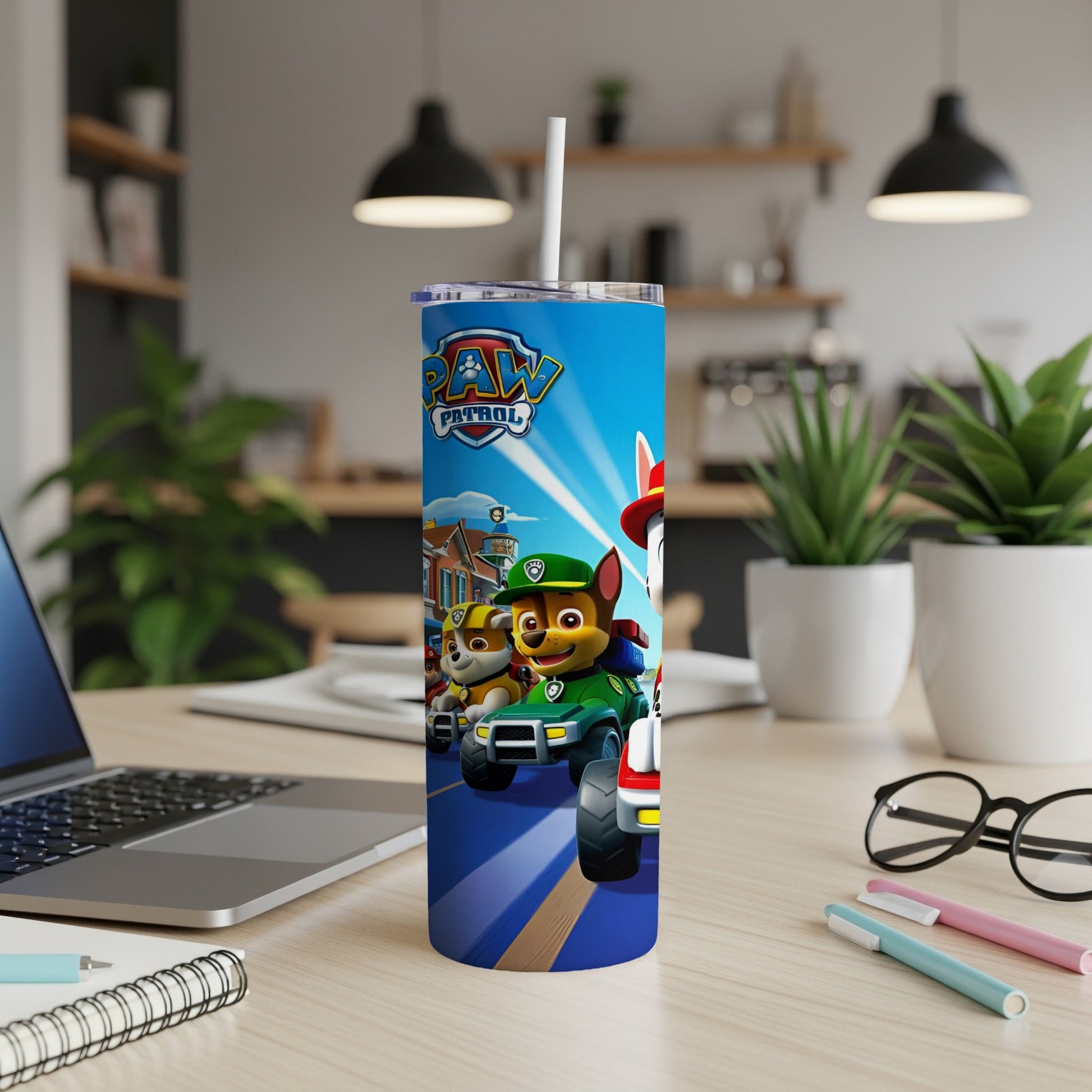 Paw Patrol characters on a blue tumbler with a straw, on a desk.