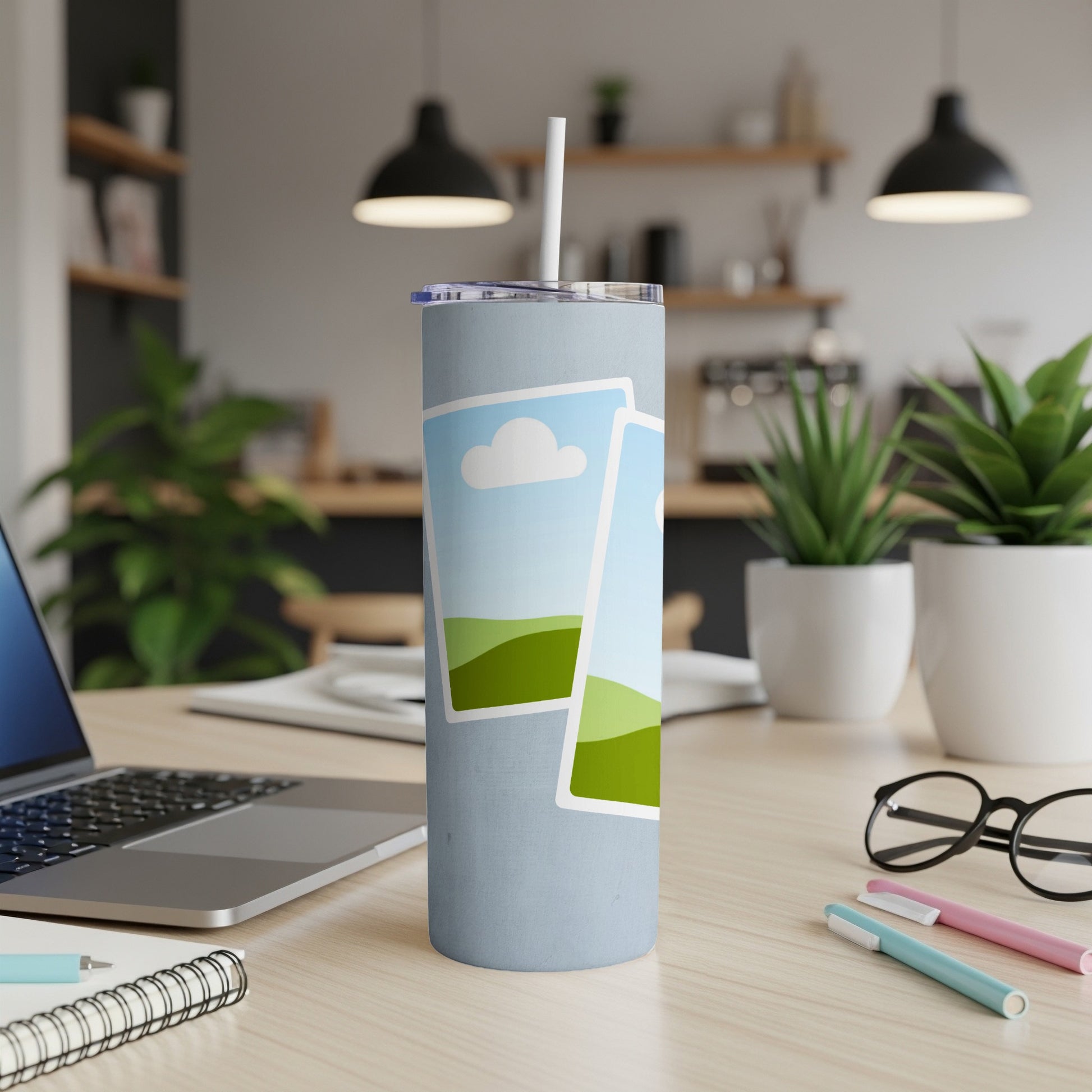 Light blue tumbler with straw, featuring two framed landscape images.