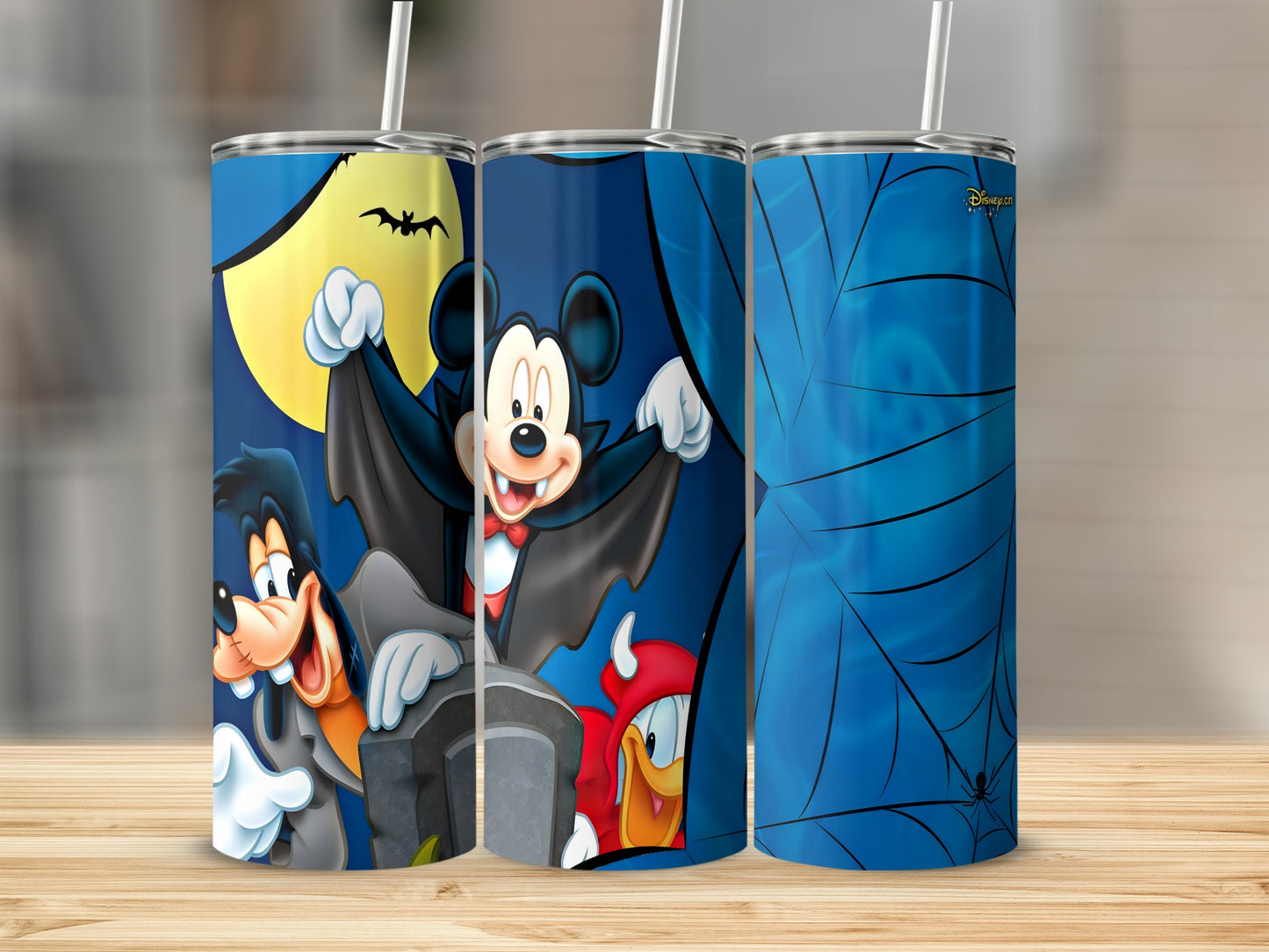 Mickey Mouse, Goofy, and Donald Duck dressed for Halloween on a tumbler.