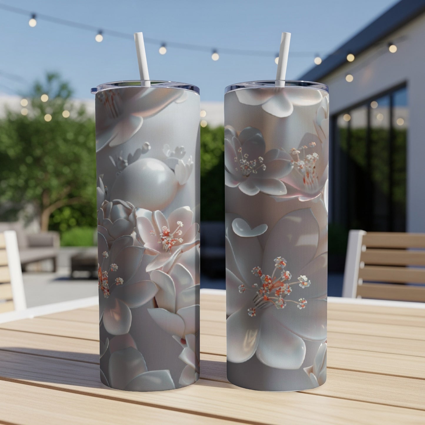 Two slim tumblers with a delicate floral pattern sit on a wooden table.