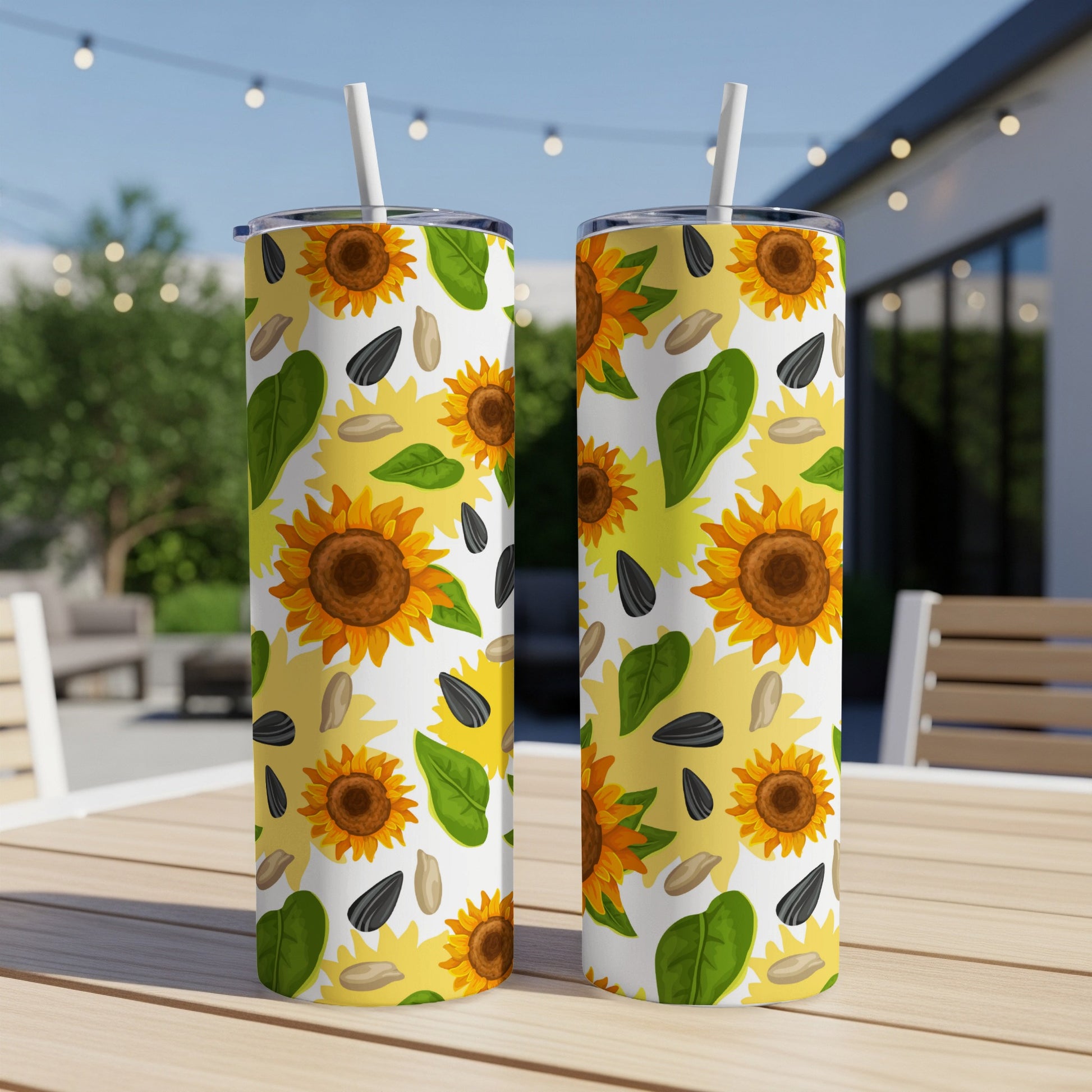Two tumblers with a cheerful sunflower and seed pattern sit on a wooden table.