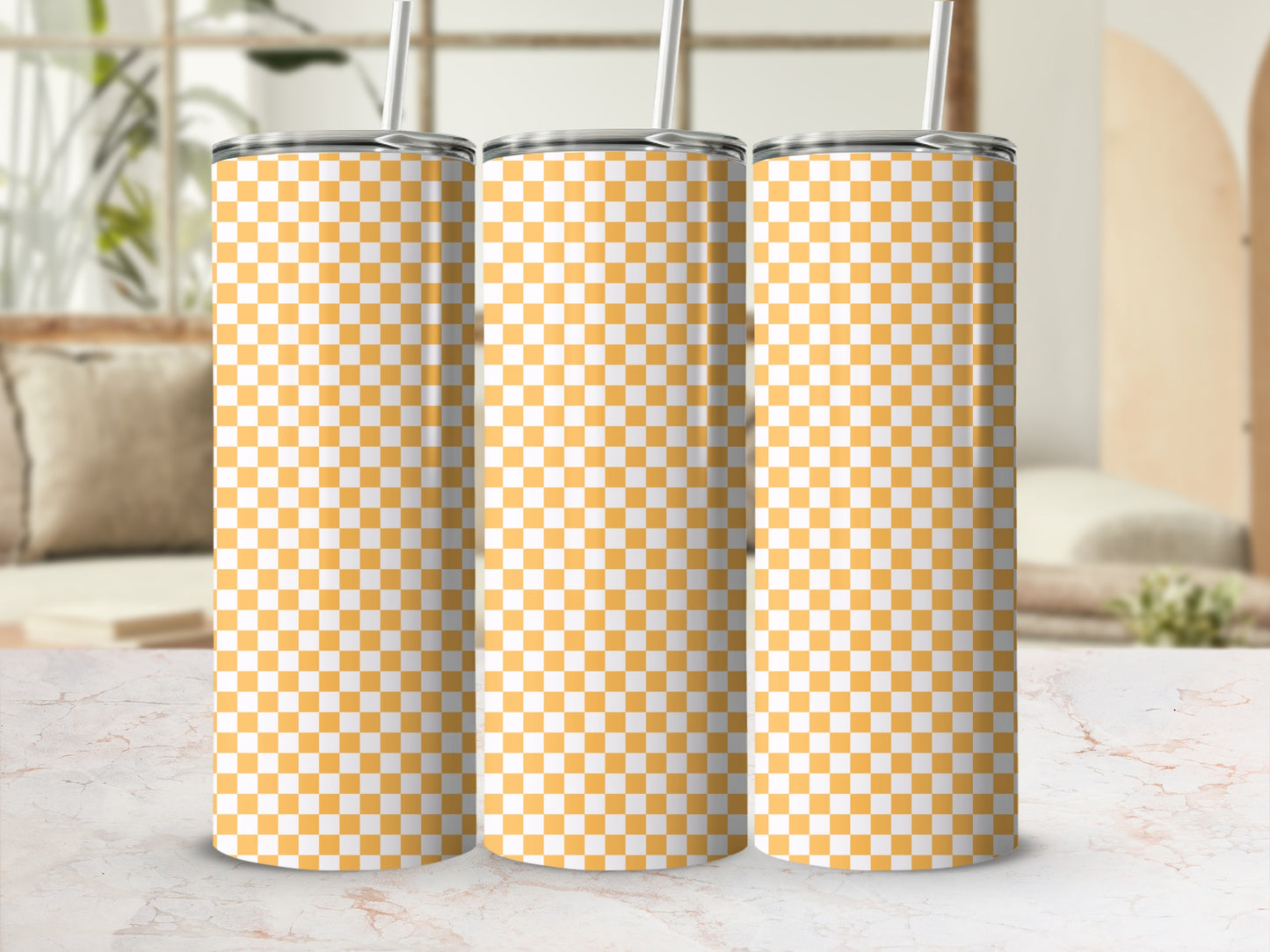 Three tumblers with orange and white checkered pattern and straws.