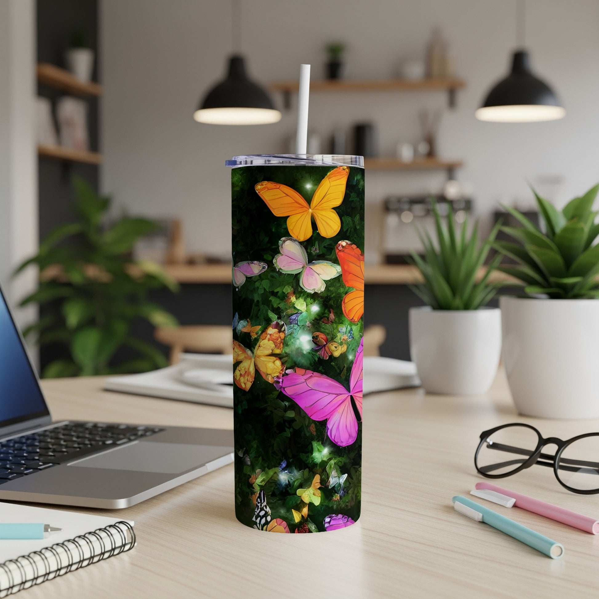 Tumbler with vibrant butterflies and floral pattern on a desk.