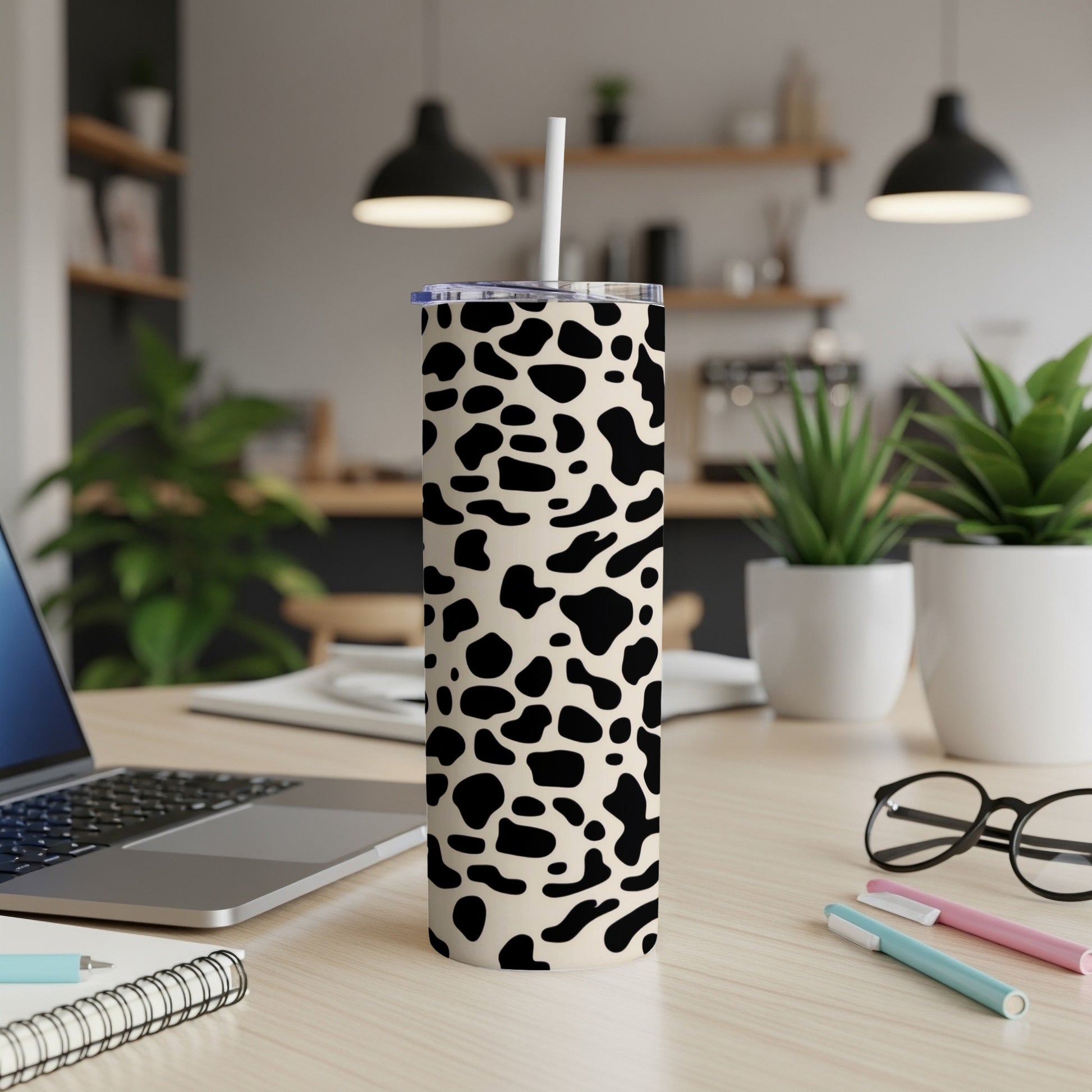 Tan skinny tumbler with black cow print and white straw.
