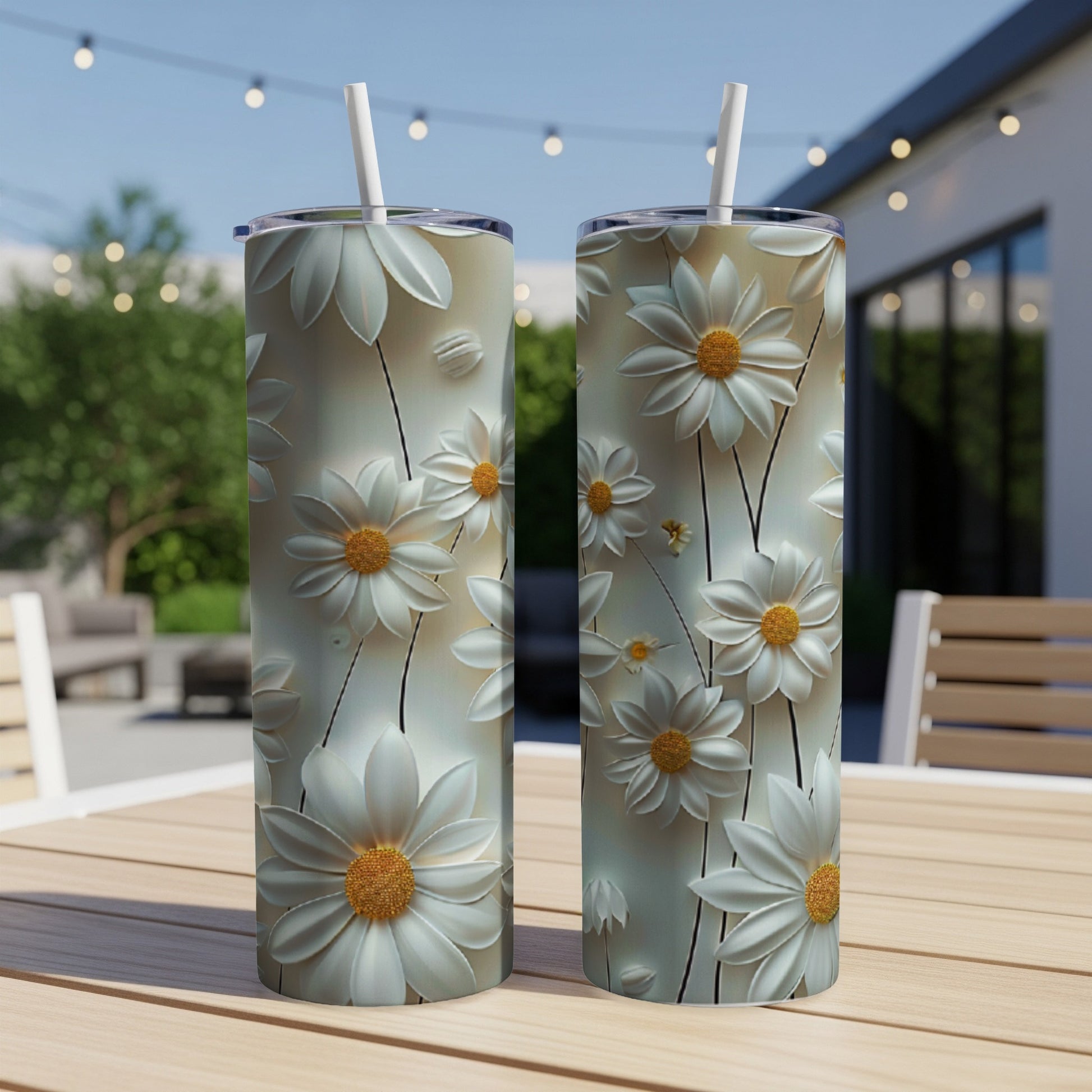 Two tall tumblers with white daisy floral pattern on a wooden table.