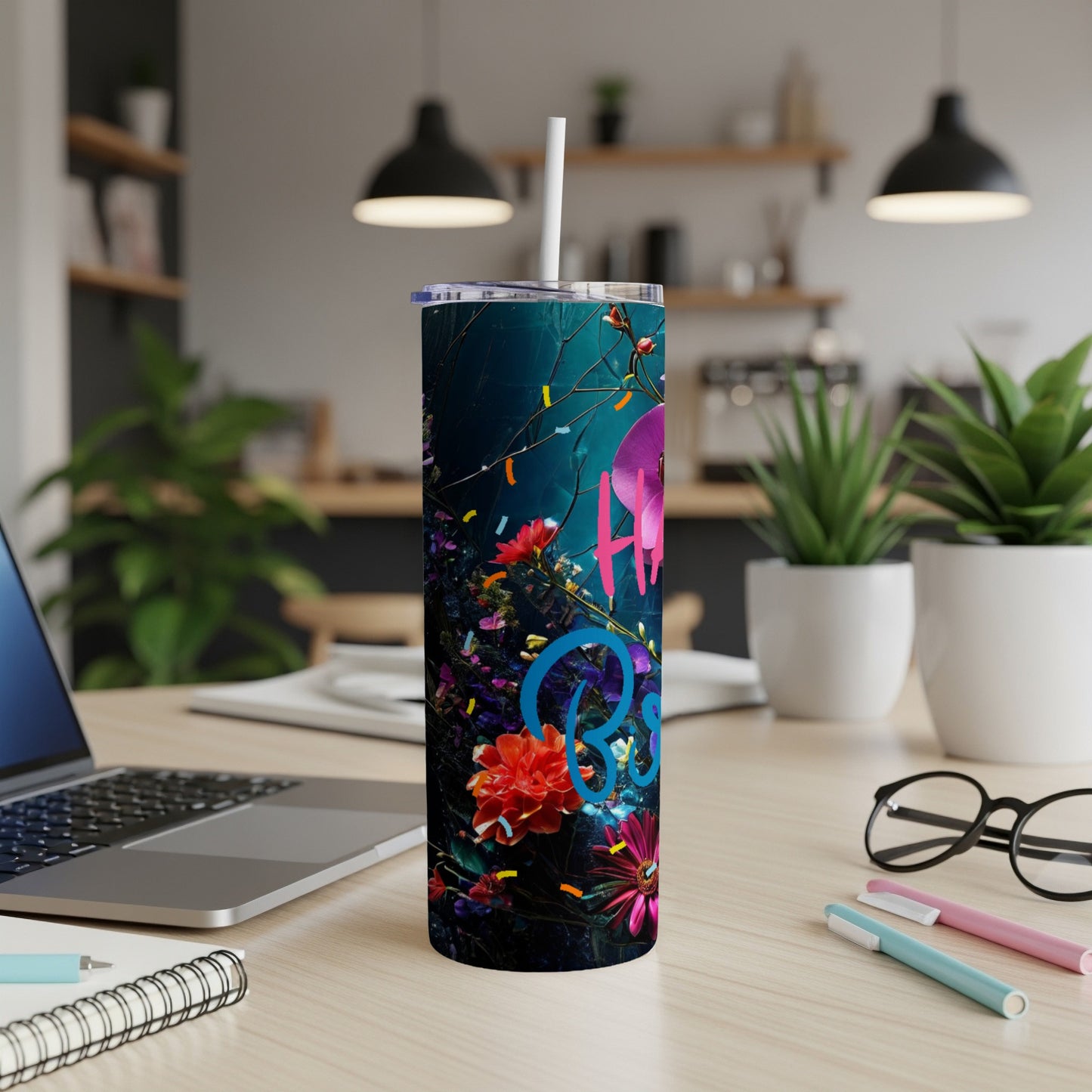 Blue and pink "Happy Birthday" text on a floral tumbler with a straw.