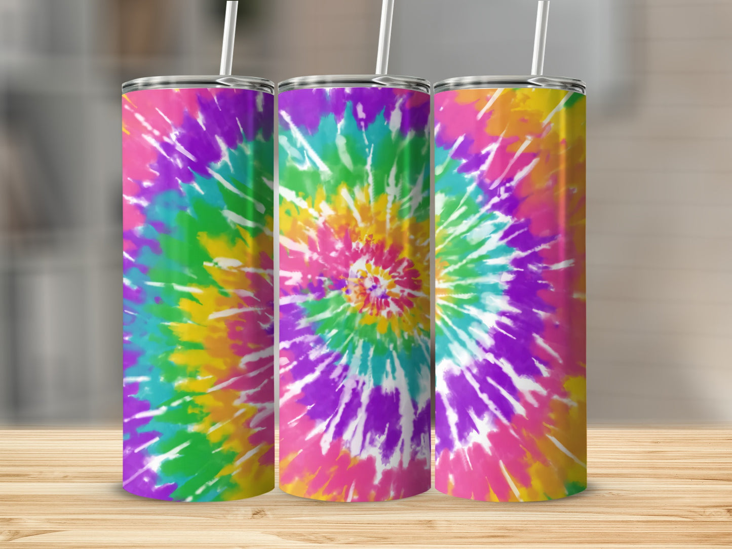 Three tumblers with a colorful tie-dye spiral pattern on a wooden surface.