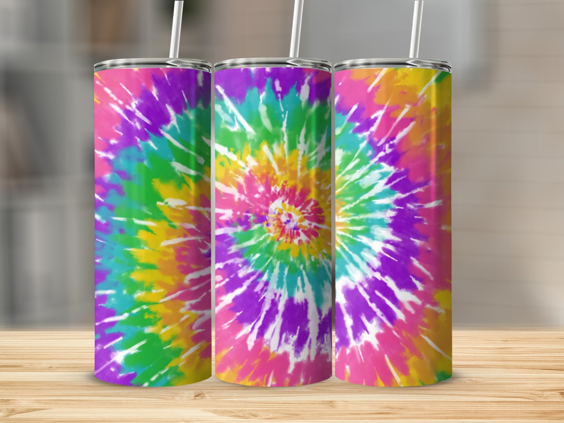 Three tumblers with a colorful tie-dye spiral pattern on a wooden surface.