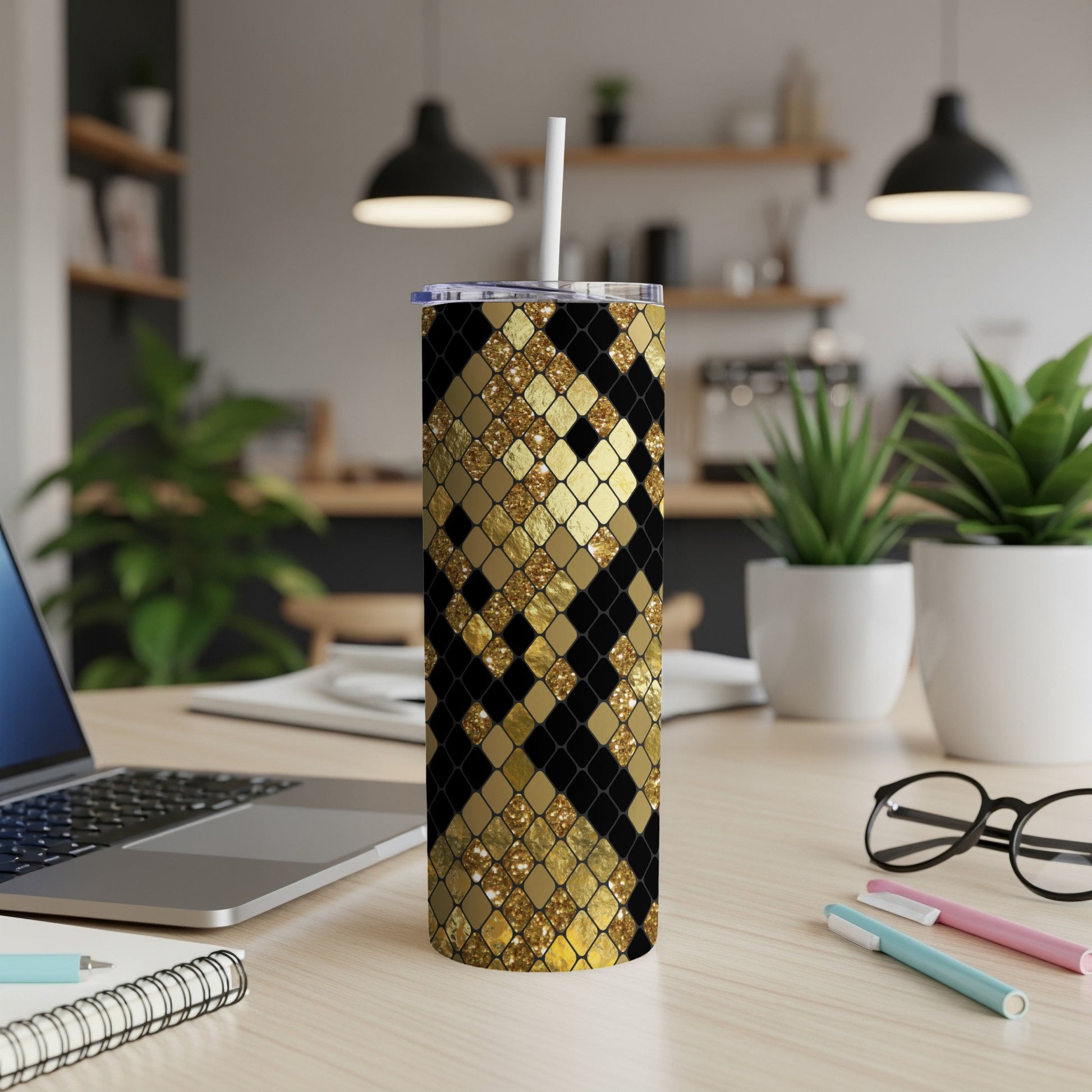 Tumbler with black and gold glitter diamond pattern, on a desk.