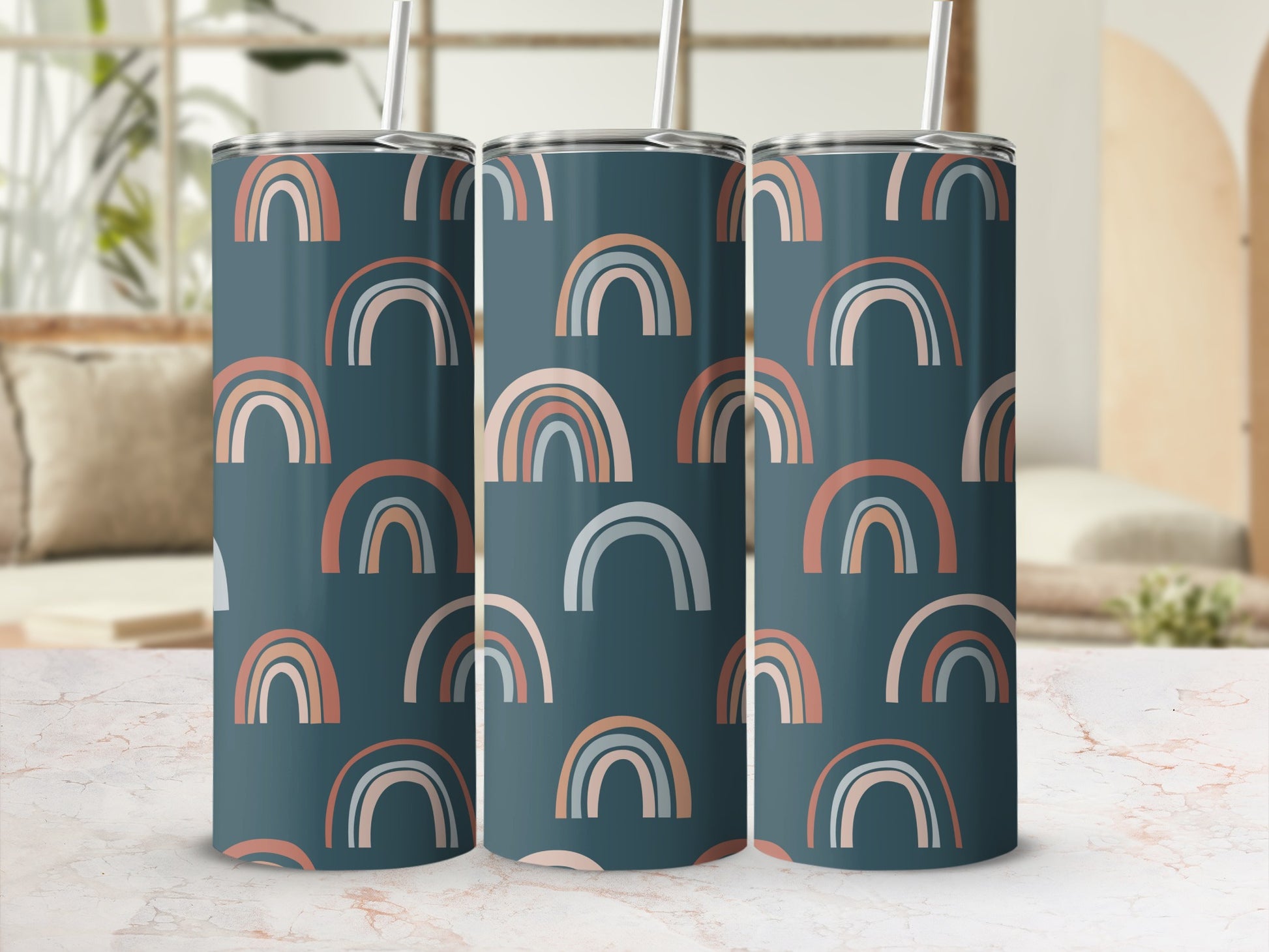 Three dark blue tumblers with a muted rainbow pattern and white straws.