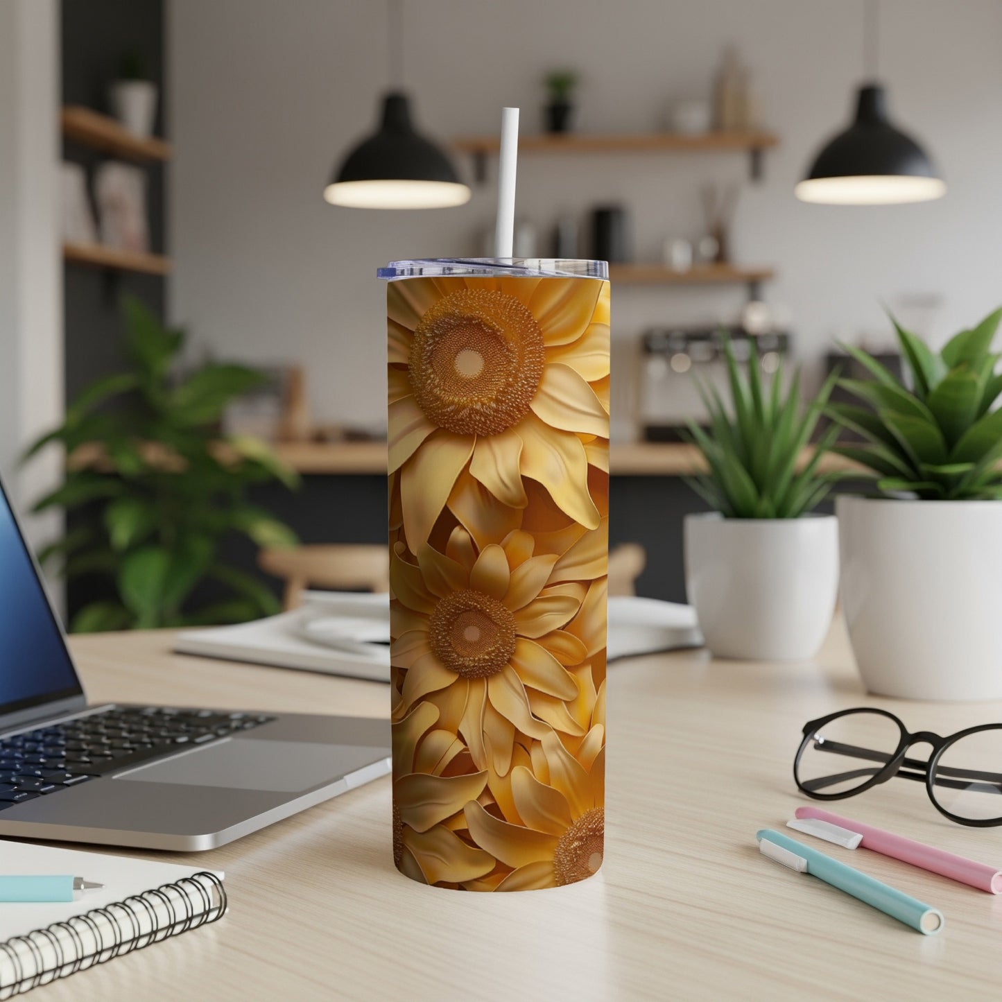 Sunflower pattern on a white tumbler with straw on a desk.