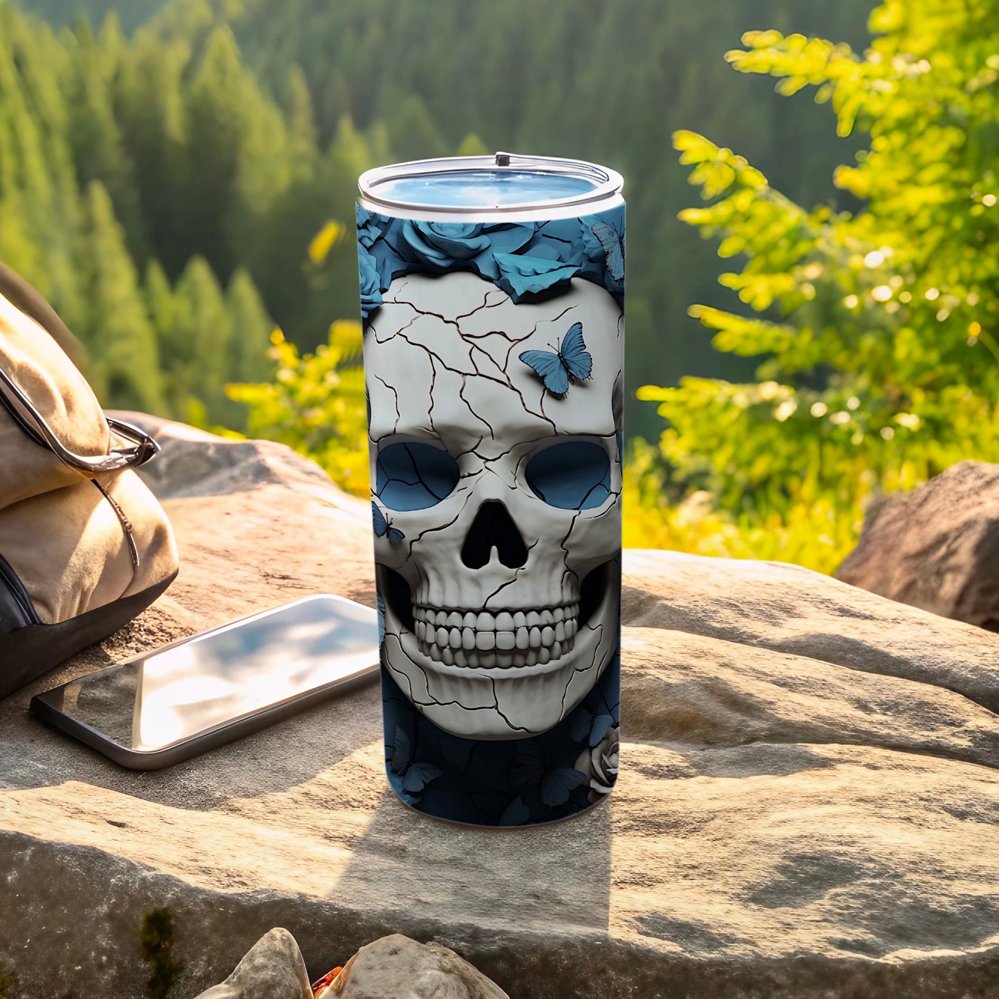 Skull tumbler with blue butterflies and roses, set outdoors.