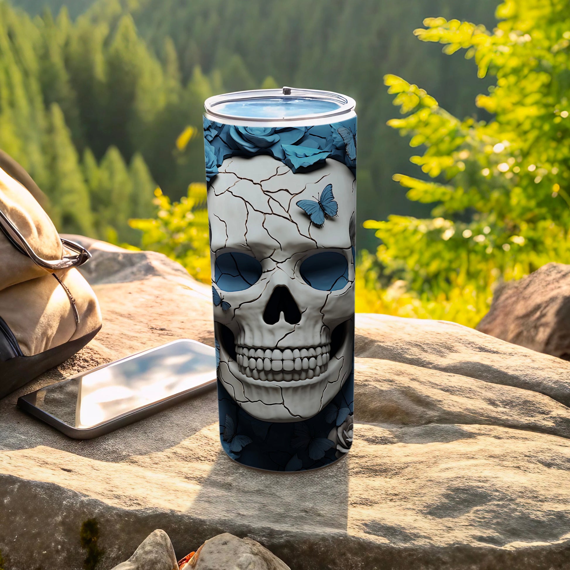 Skull tumbler with blue butterflies and roses, set outdoors.