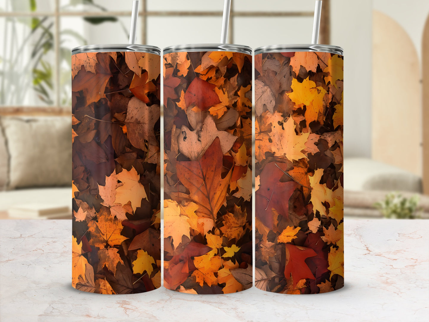 Three tumblers with autumn leaves design and straws.