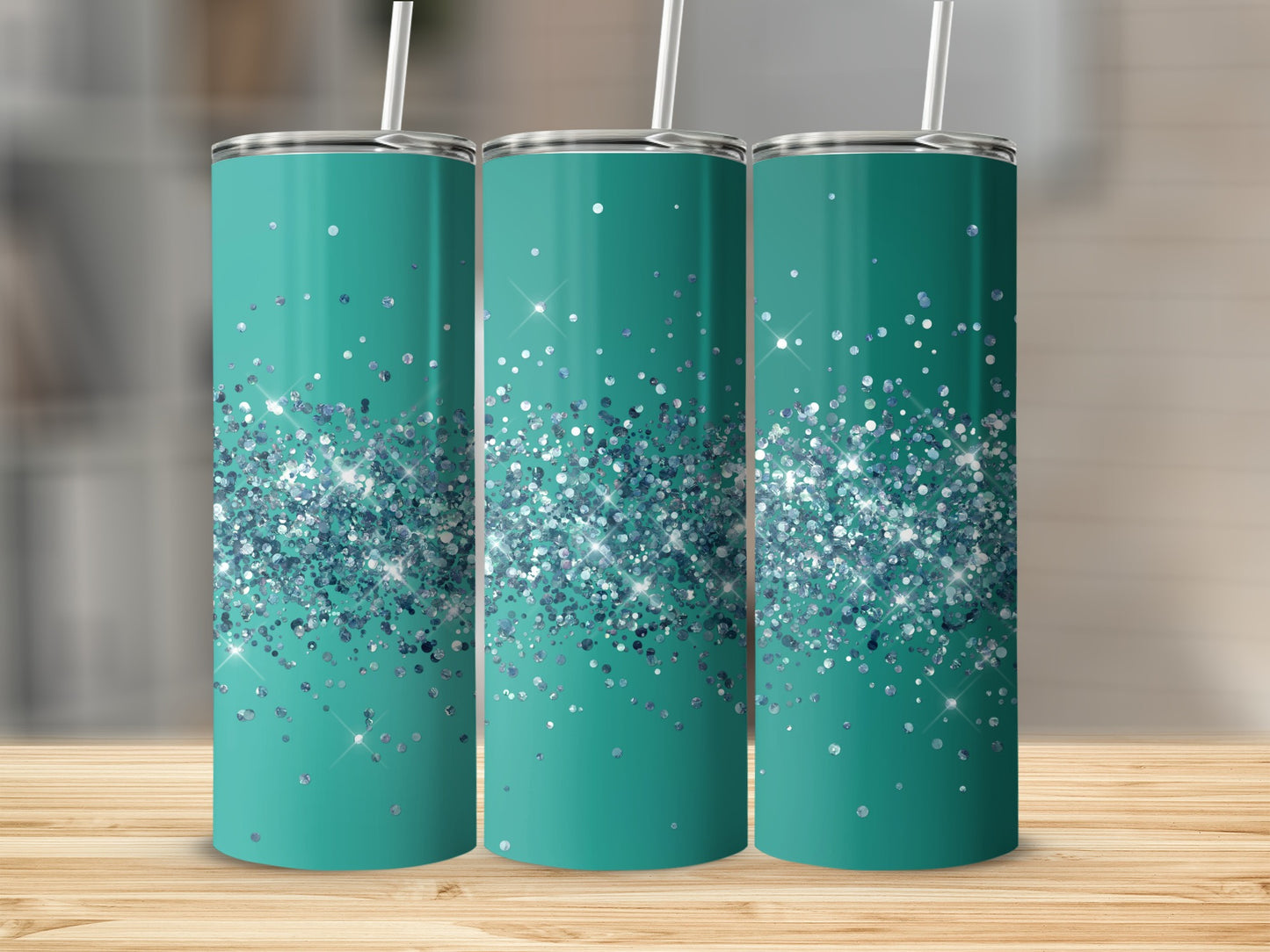 Three teal tumblers with silver glitter designs and white straws.