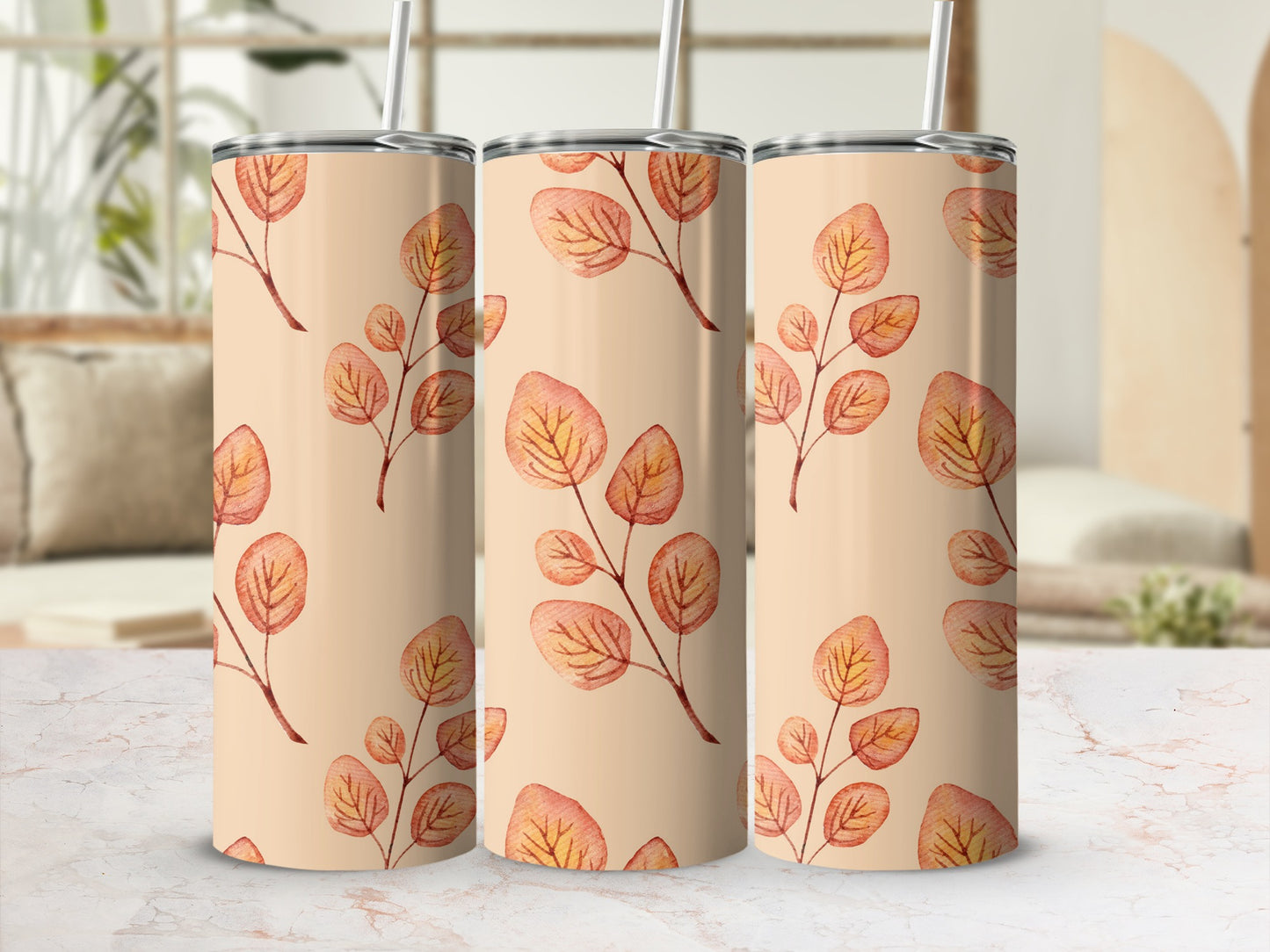 Three tall tumblers with a repeating peach and orange leaf branch pattern.