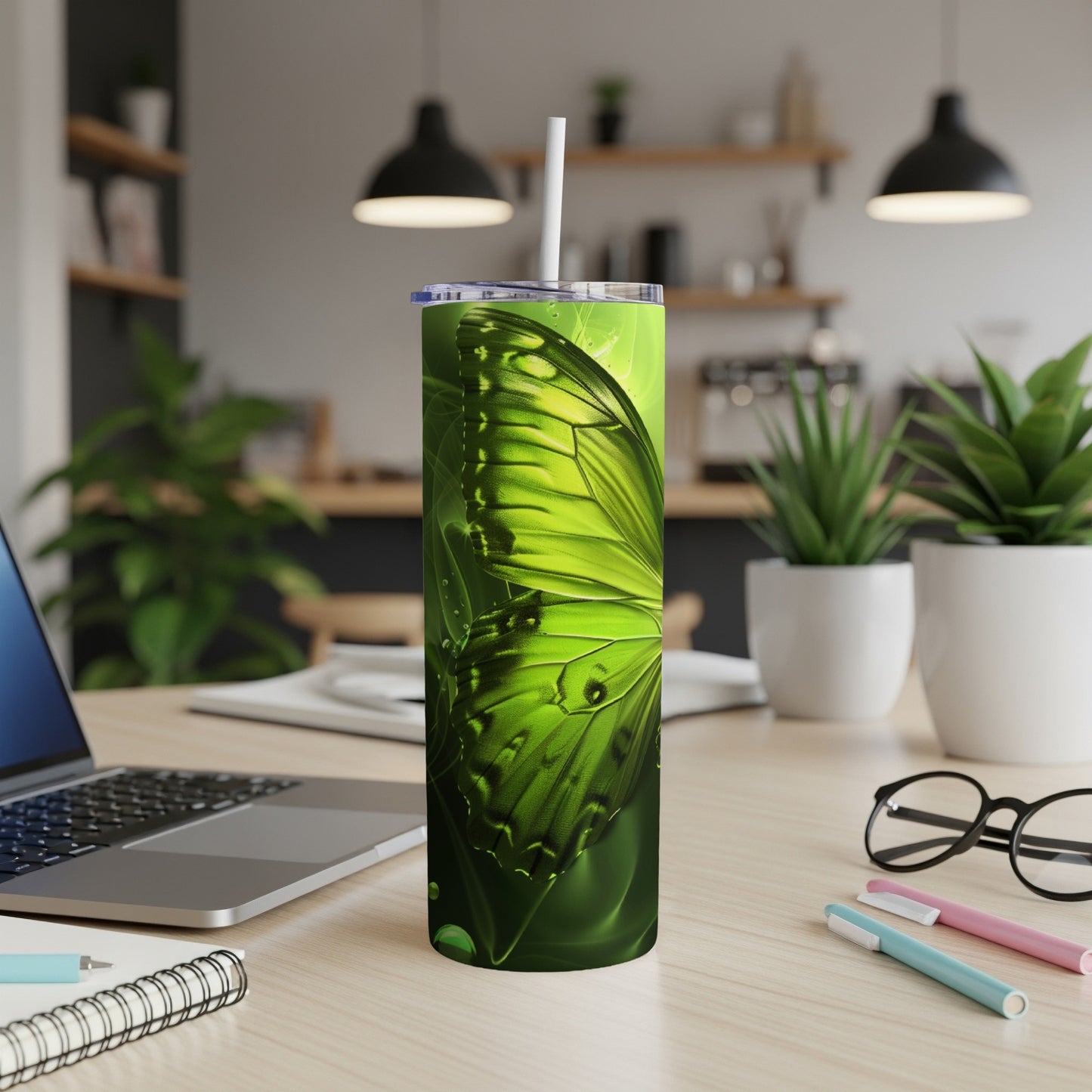 Green butterfly wing design on a white tumbler with a straw.