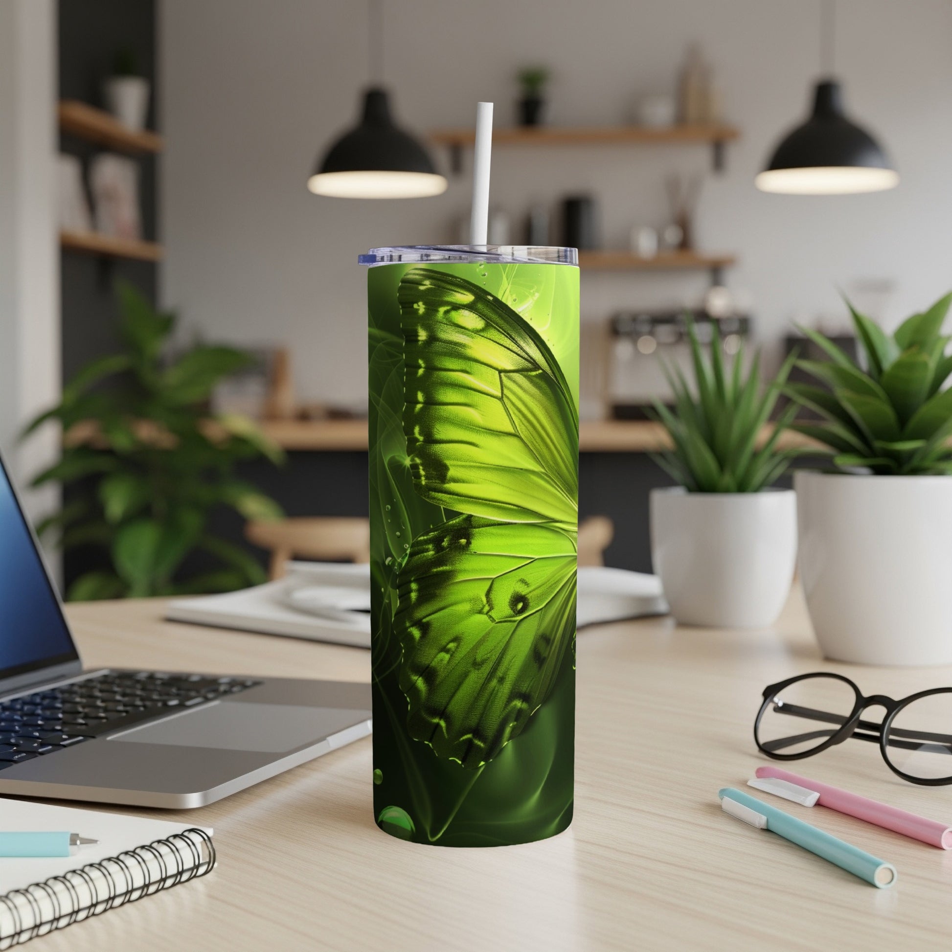 Green butterfly wing design on a white tumbler with a straw.