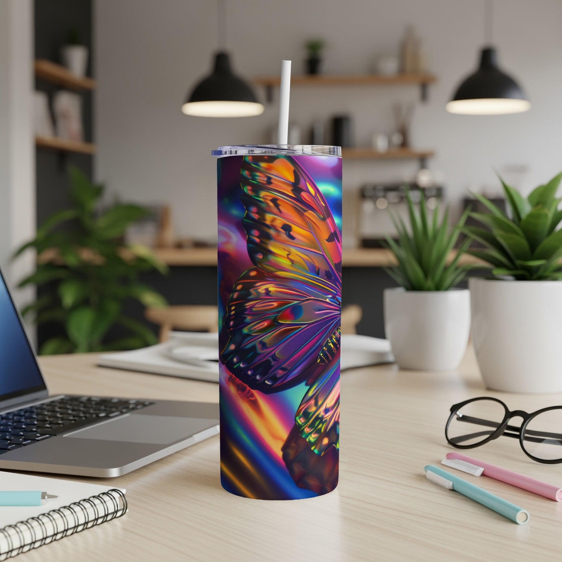 Iridescent butterfly tumbler with straw on a desk.