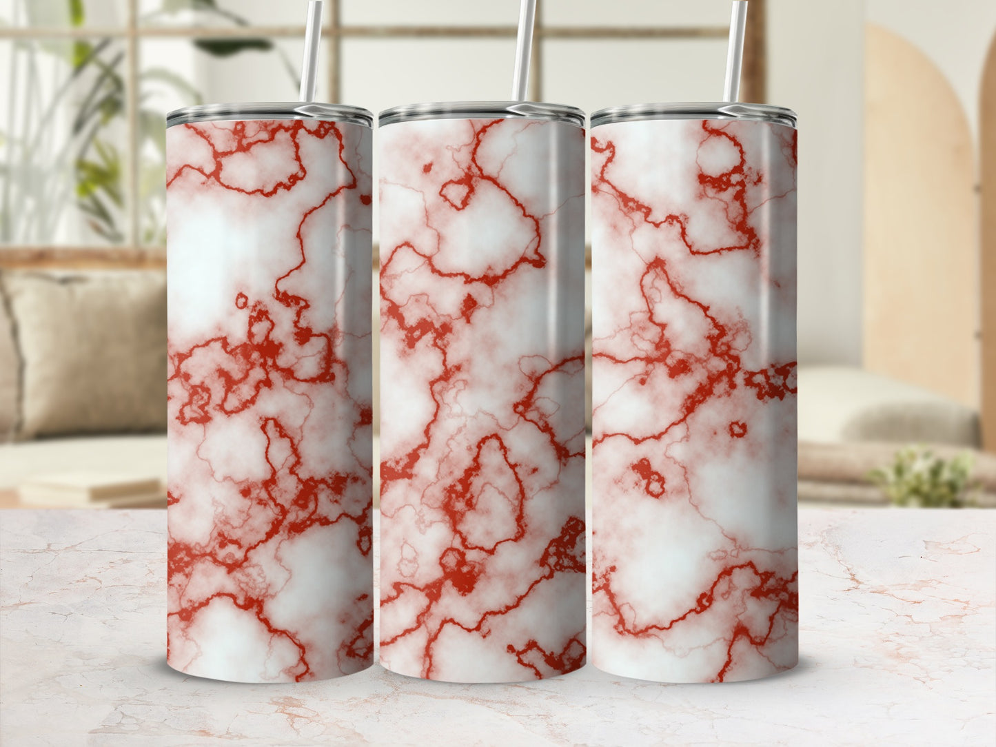Three white tumblers with red marble pattern and straws.