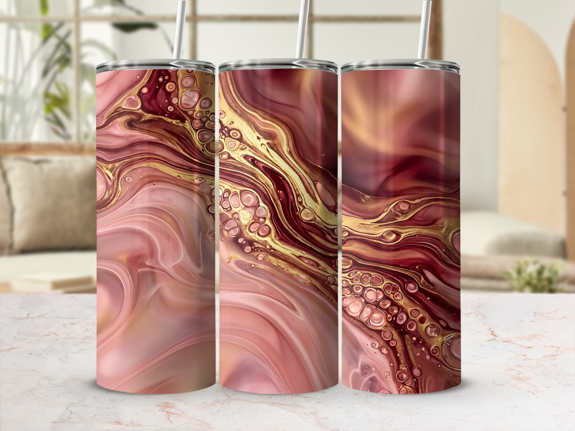 Three skinny tumblers with a pink and gold abstract marbling design.