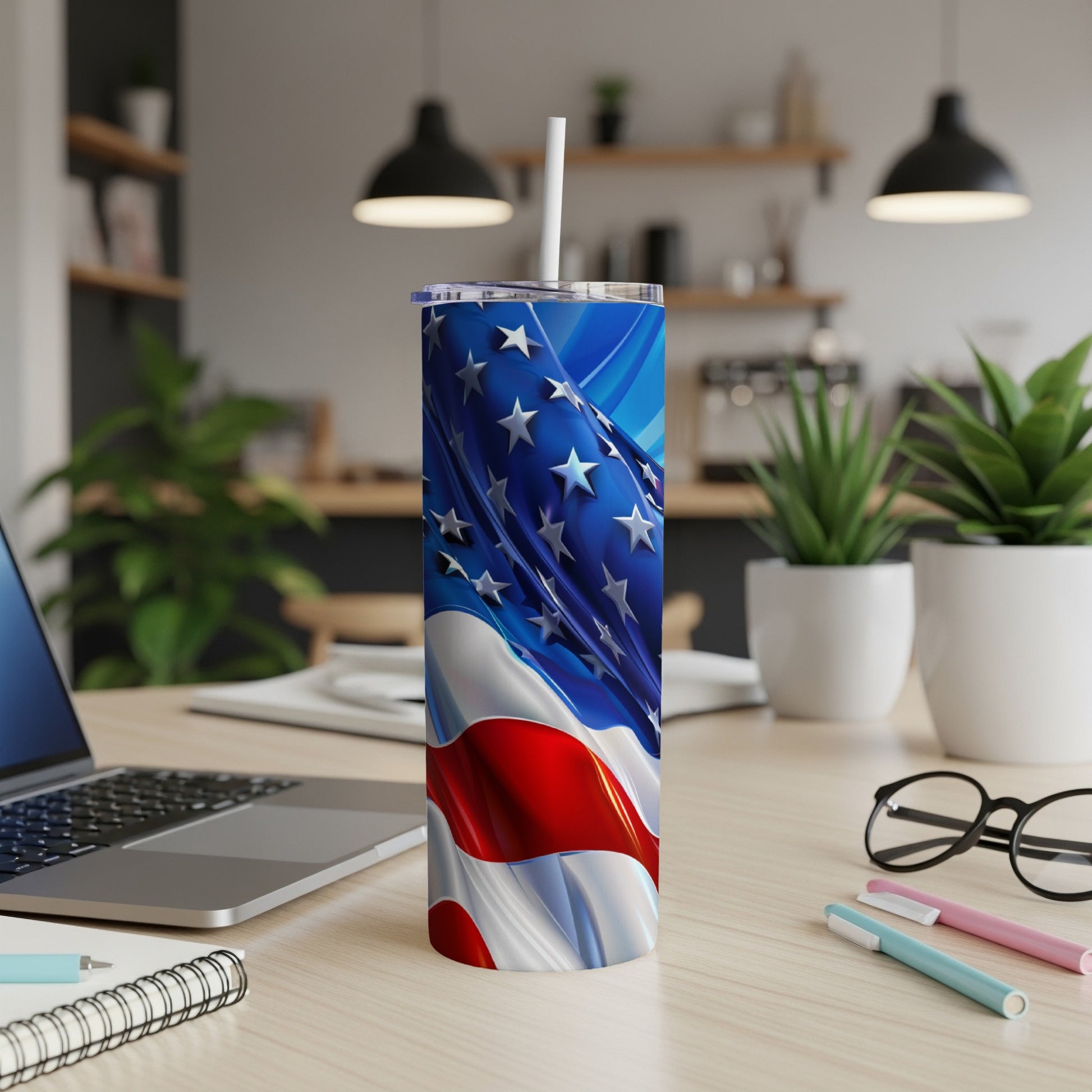 Tumbler with American flag design and straw on a wooden desk.