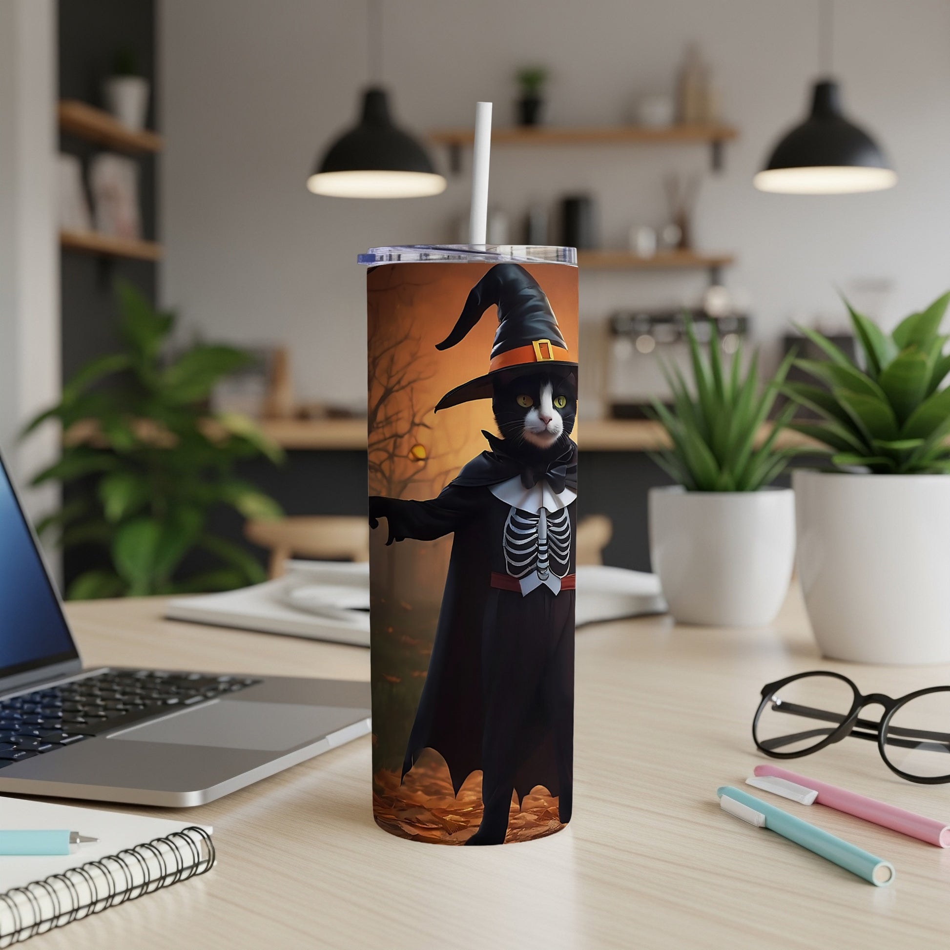 Black cat wearing a witch hat and skeleton costume on a Halloween-themed tumbler.