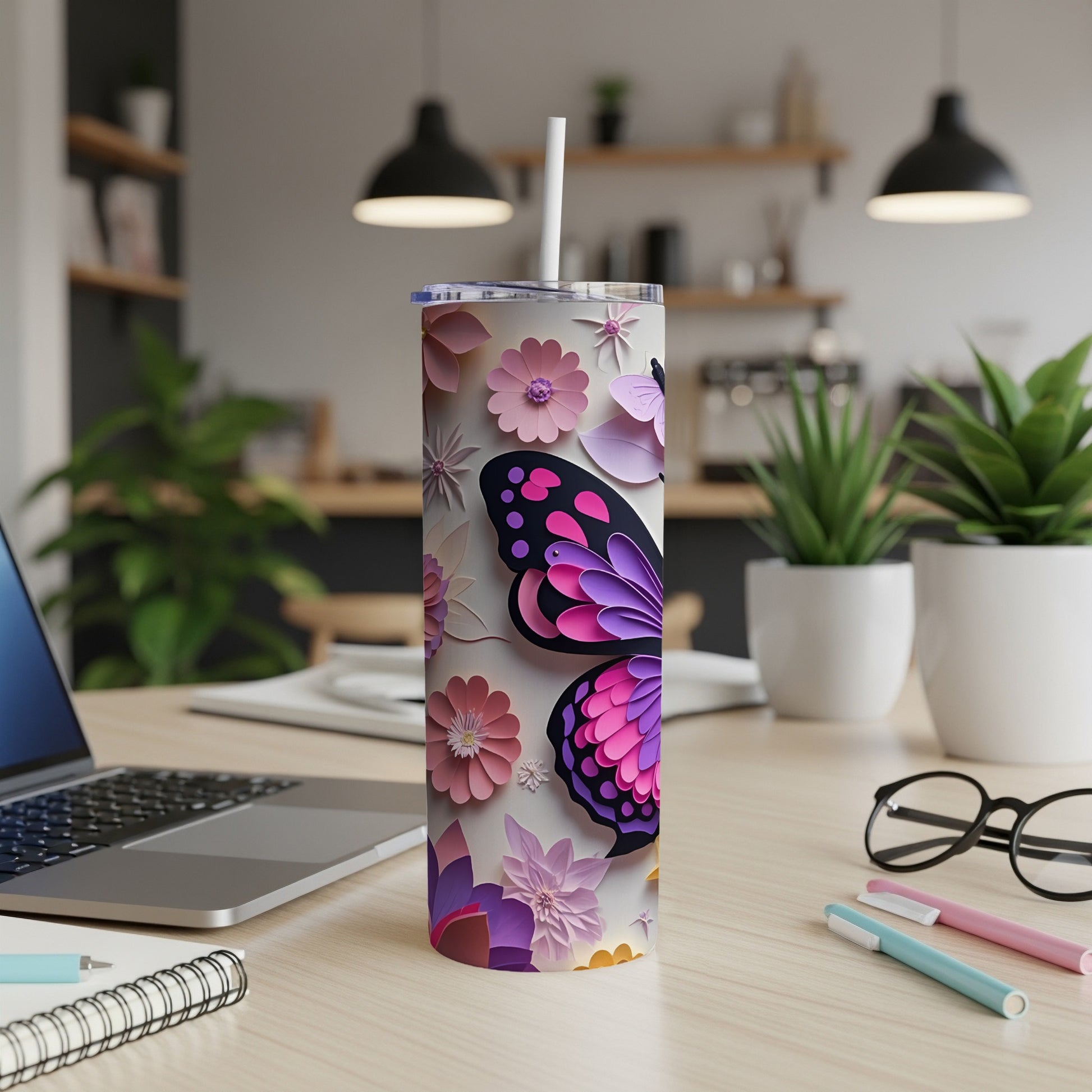 White tumbler with butterfly and floral design, featuring a straw.
