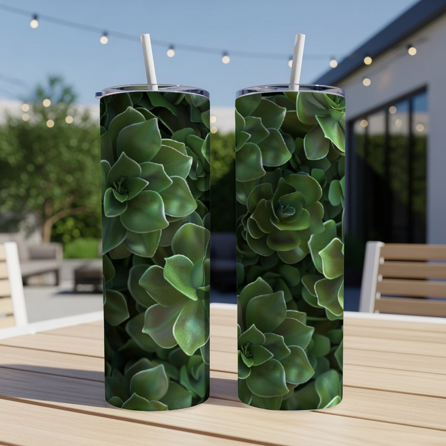 Two green succulent-patterned tumblers on a wooden table outdoors.