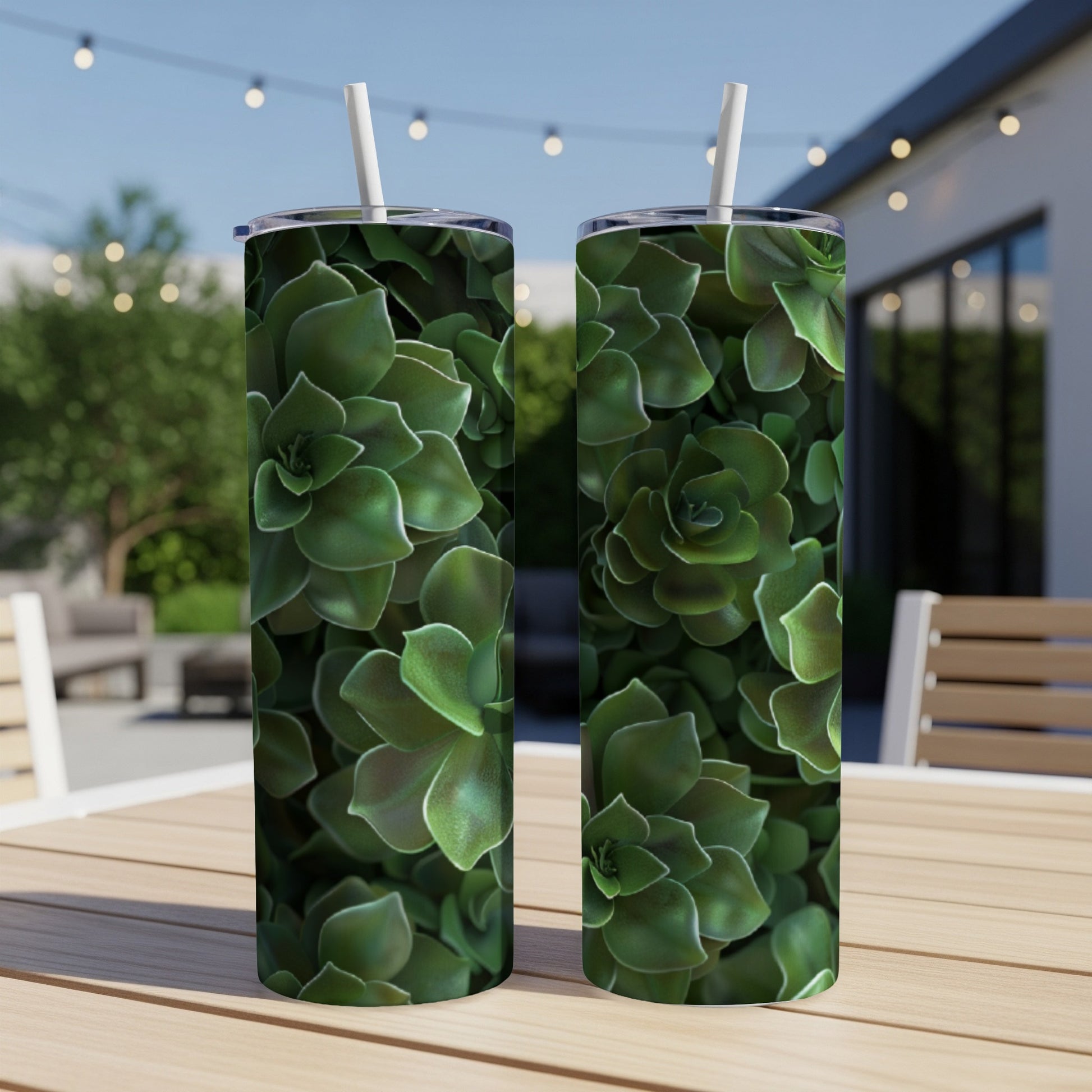 Two green succulent-patterned tumblers on a wooden table outdoors.