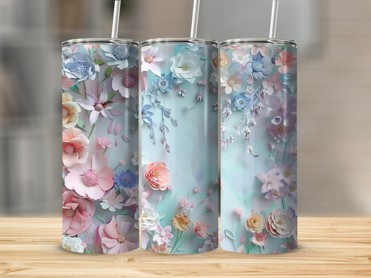 Three tumblers with floral designs in pastel colors on a wooden surface.
