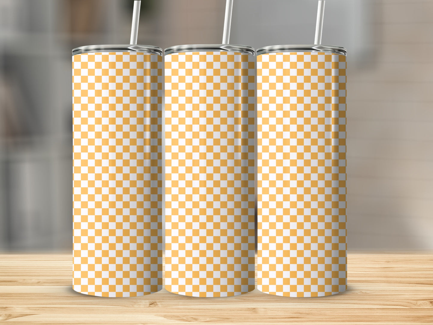 Three tall tumblers with a yellow and white checkerboard pattern on a wooden surface.