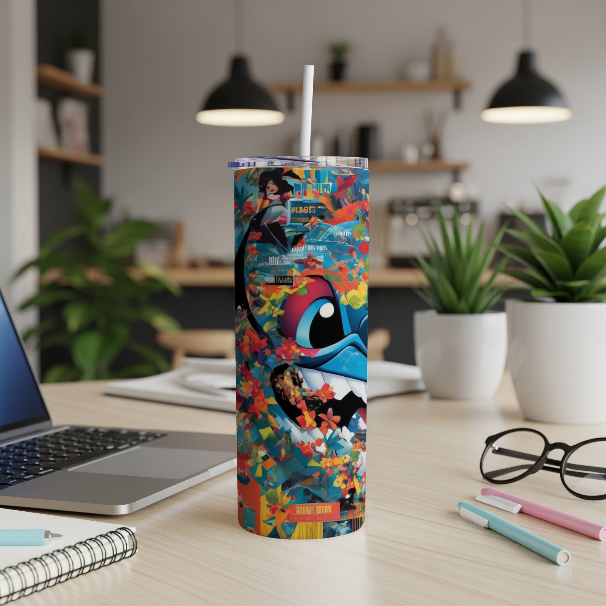 Tumbler with colorful cartoon monster design, laptop, and office supplies.
