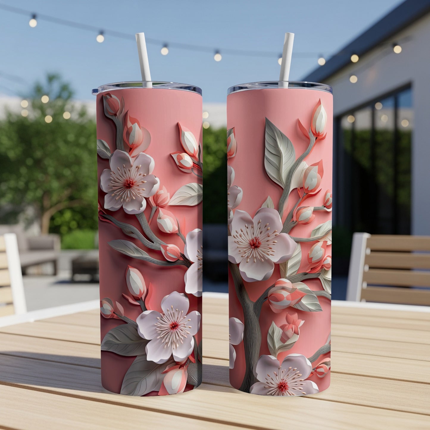 Two pink tumblers with a floral cherry blossom design on a wooden table.