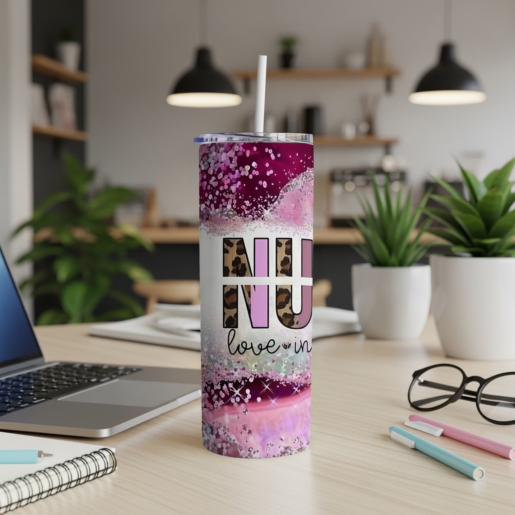 Purple glitter tumbler with "NU love in" text on desk.