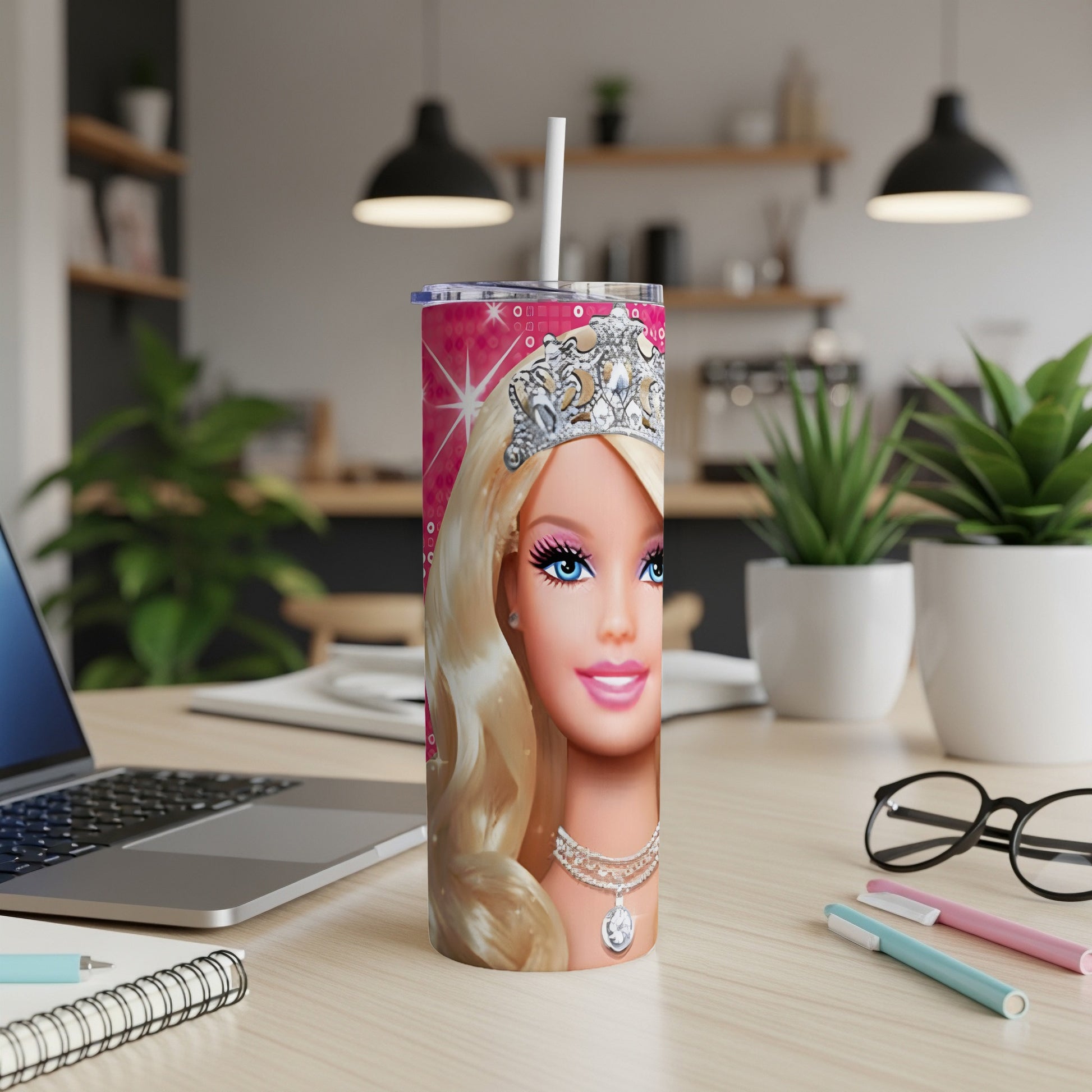Barbie tumbler with crown and necklace, on a desk with a laptop.