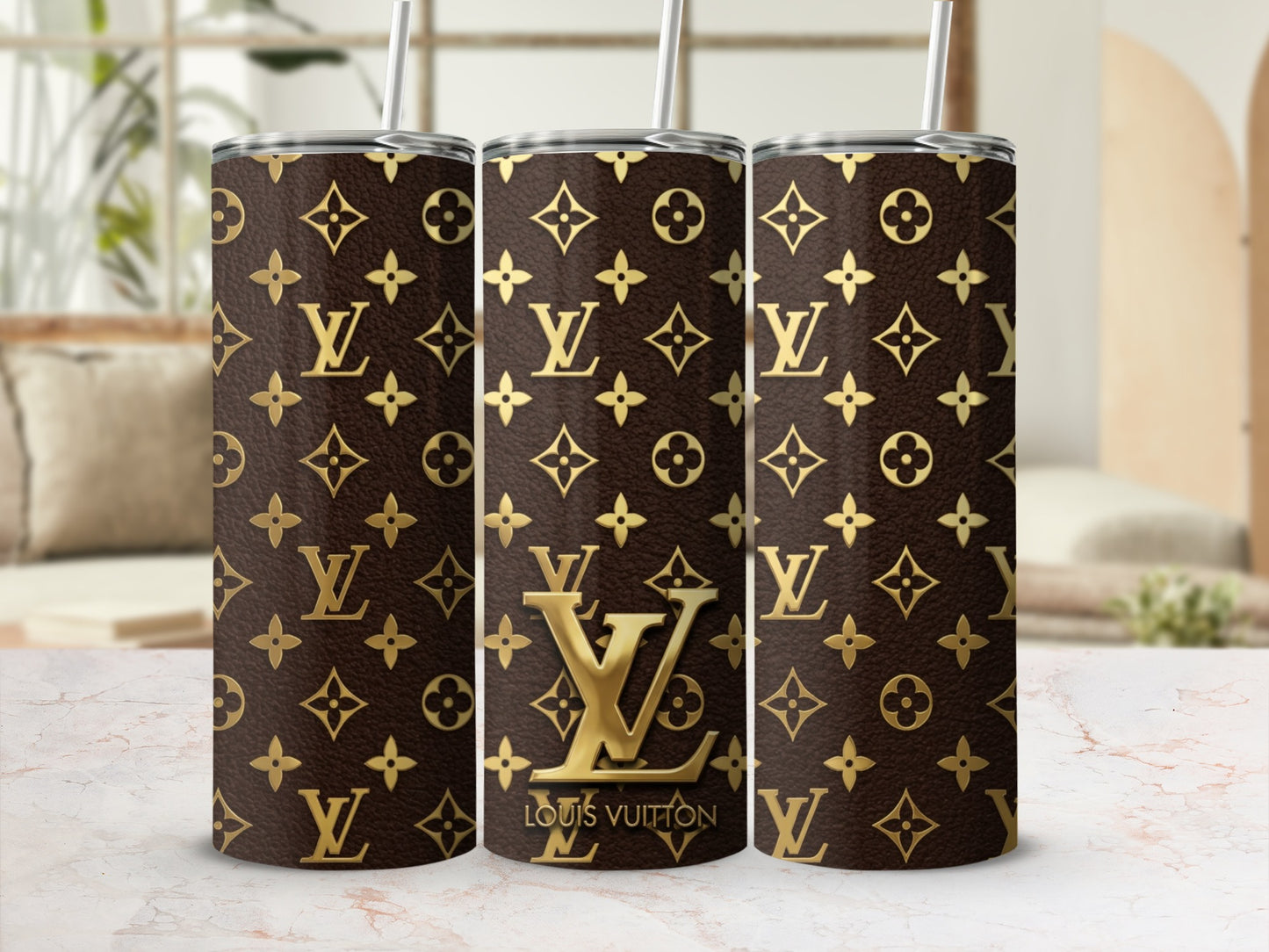 Three tumblers with brown and gold Louis Vuitton monogram pattern and straws.