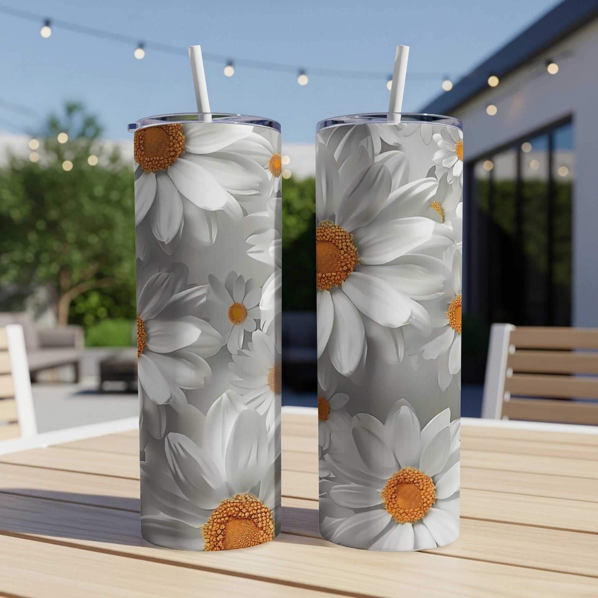 Two white daisy tumblers with orange centers on a table.