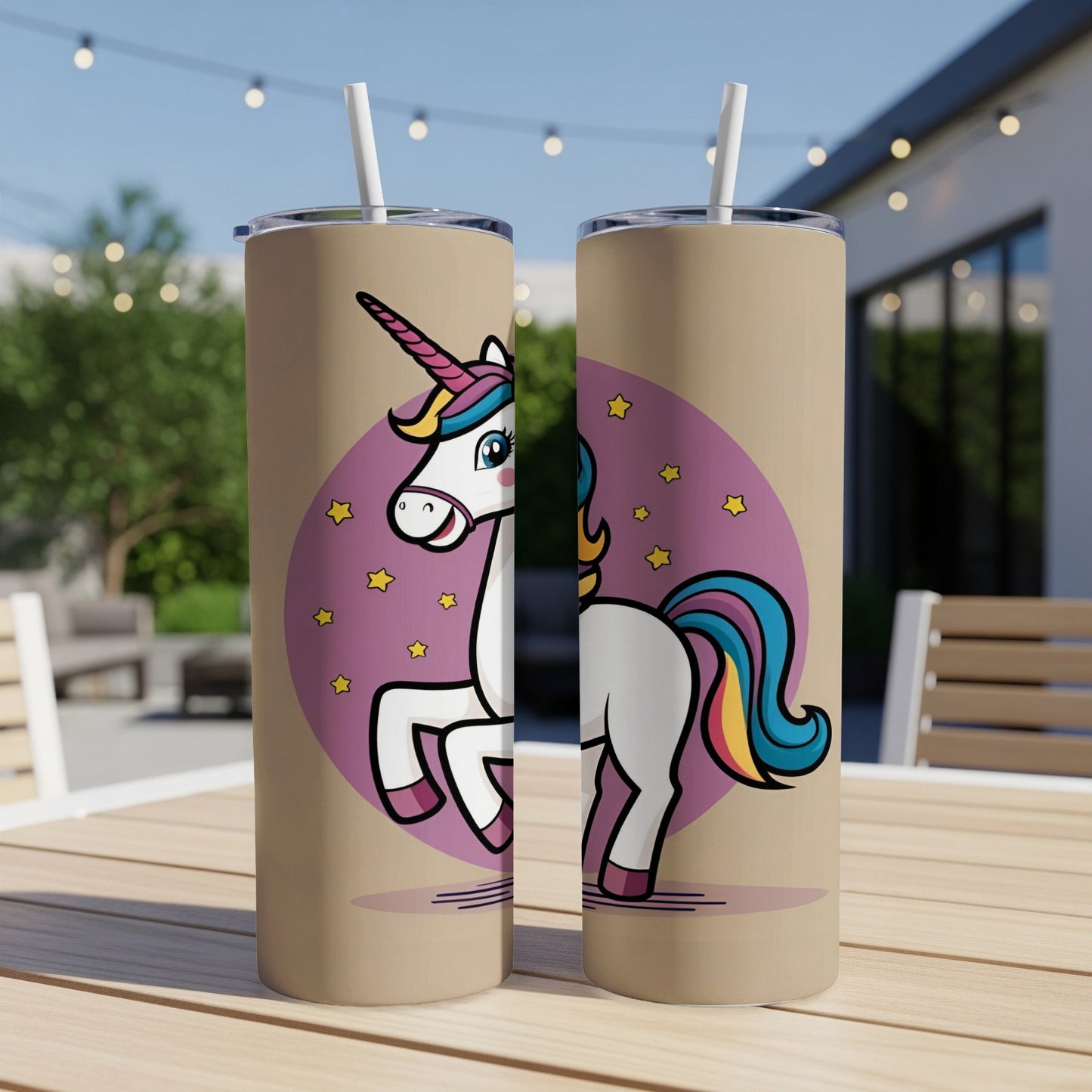 Two tall tumblers with a cartoon unicorn design on a table.